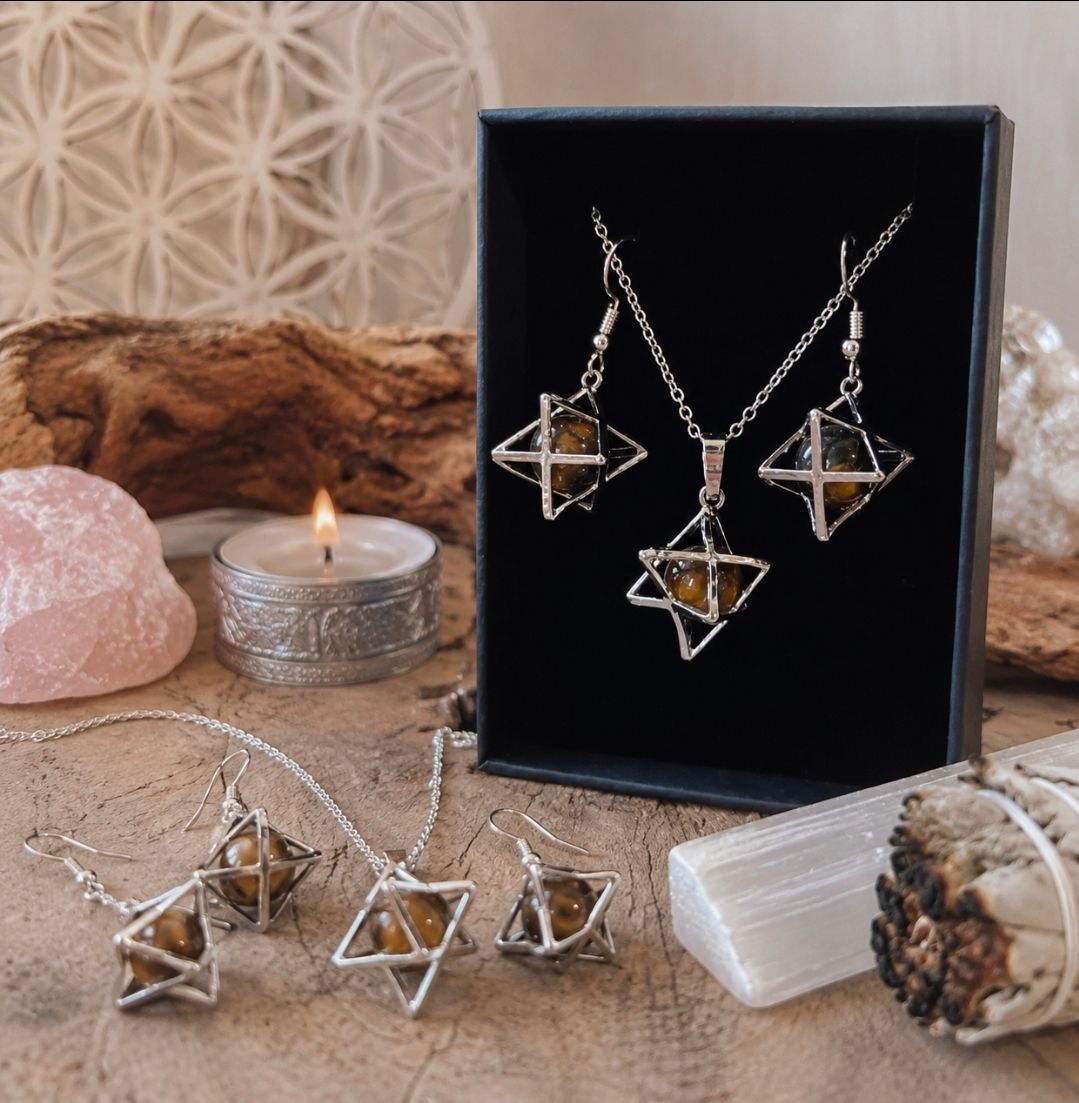 Een geometrische sieradenset van zilver met hangers van heldere kristallen, tentoongesteld in een zwarte doos