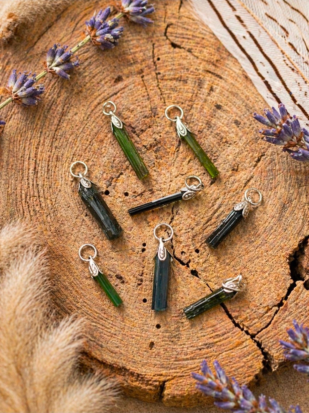 Handgemaakte kristallen hangers in zwart en groen op een houten schijfje met lavendeltakjes.