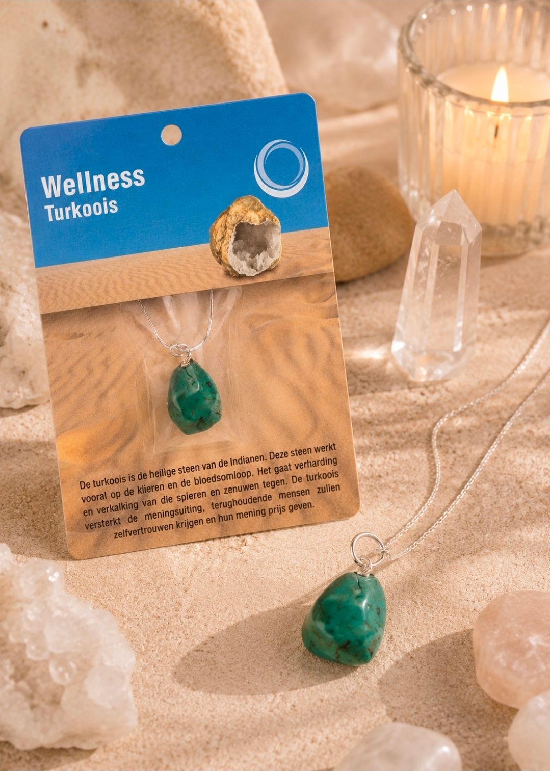 Een turquoise wellnesshanger op een kaartje, naast een bijpassende steen, kristal en kaars op een zachtbeige achtergrond.