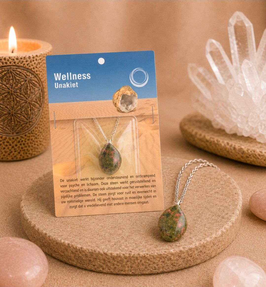 Een kaartje met wellness-oorbellen, met groene kralen oorbellen op een beige display, naast een kaars