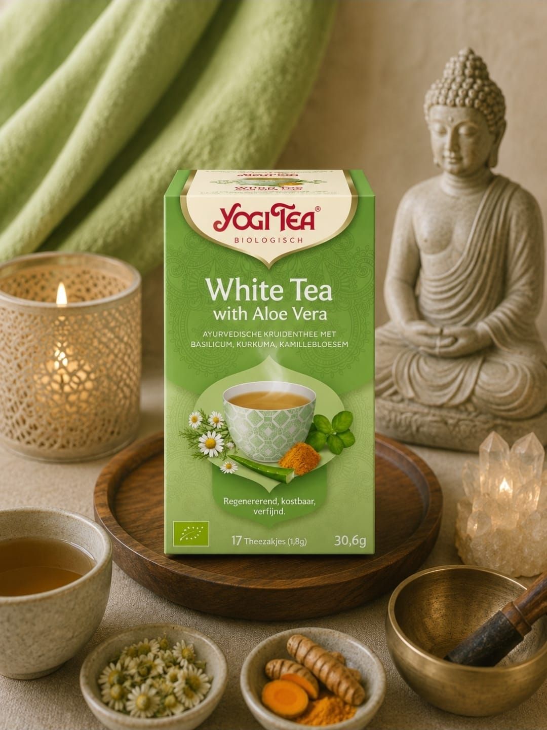 Een doosje Yogi Tea witte thee met aloë vera, gepresenteerd op een serene theetafel met kaarsen, een Boeddhabeeldje
