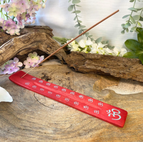 Rode liniaal met een houten stok, geplaatst op een rustieke houten ondergrond, omringd door decoratieve bloemen en bladeren.