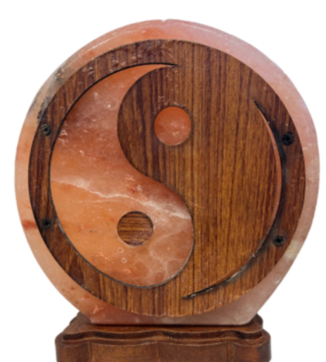 Een stralende yin-yang lamp op een houten voet, met oranje en donkerbruine accenten.