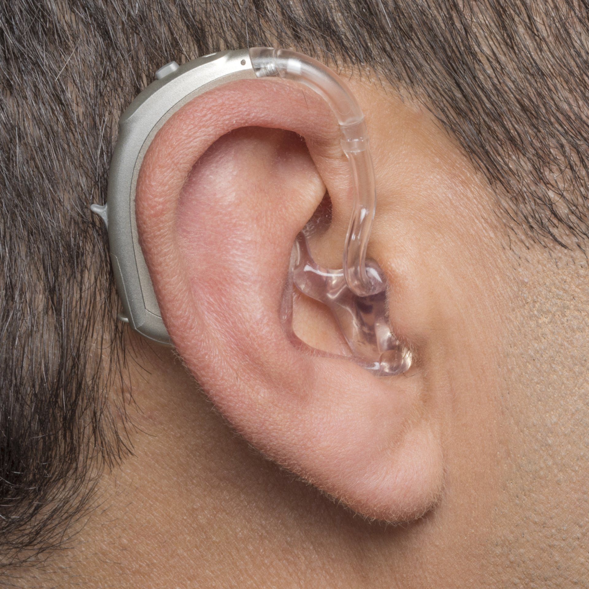 A man wearing a hearing aid in his left ear