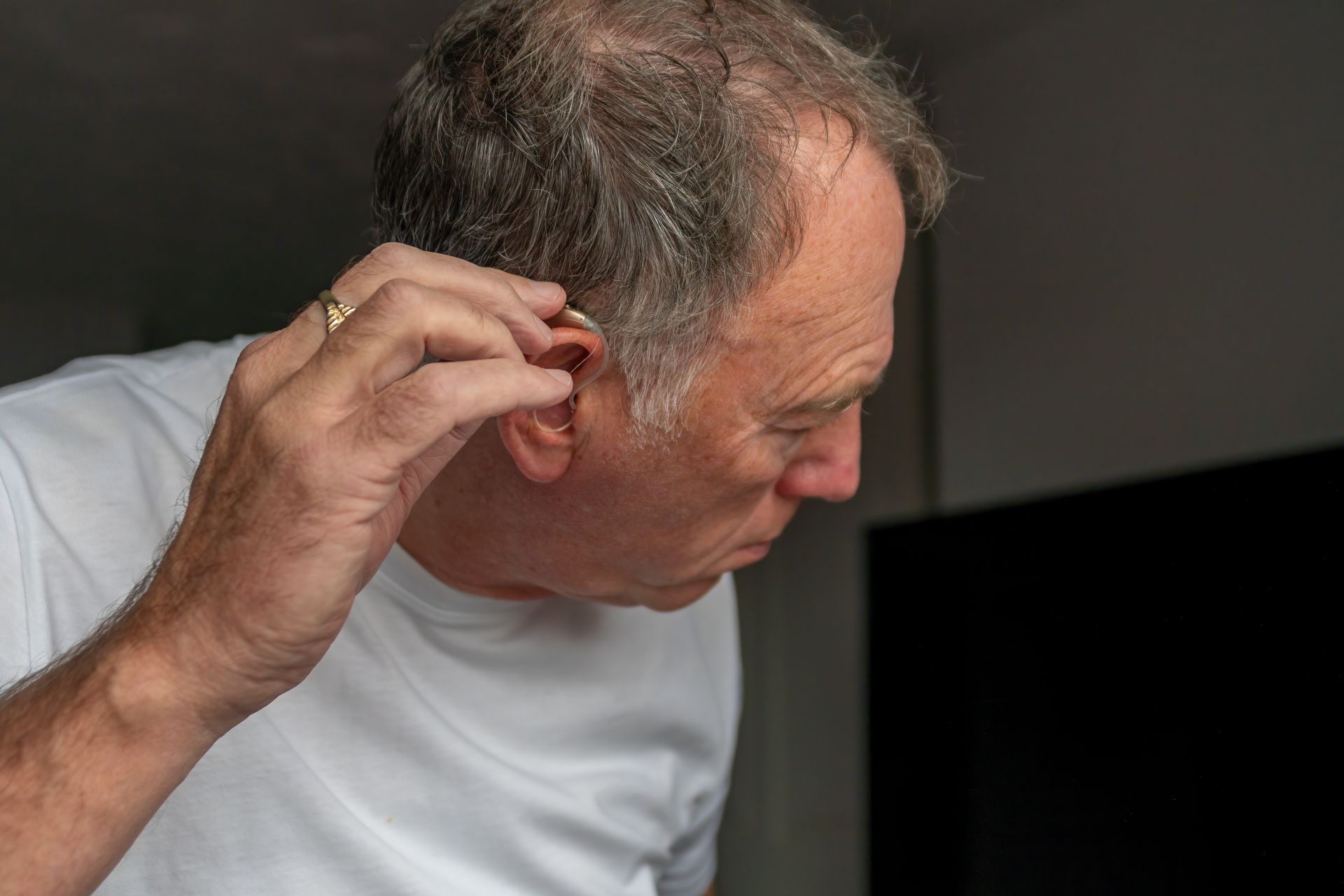 A man is cleaning his ear with a cotton swab.