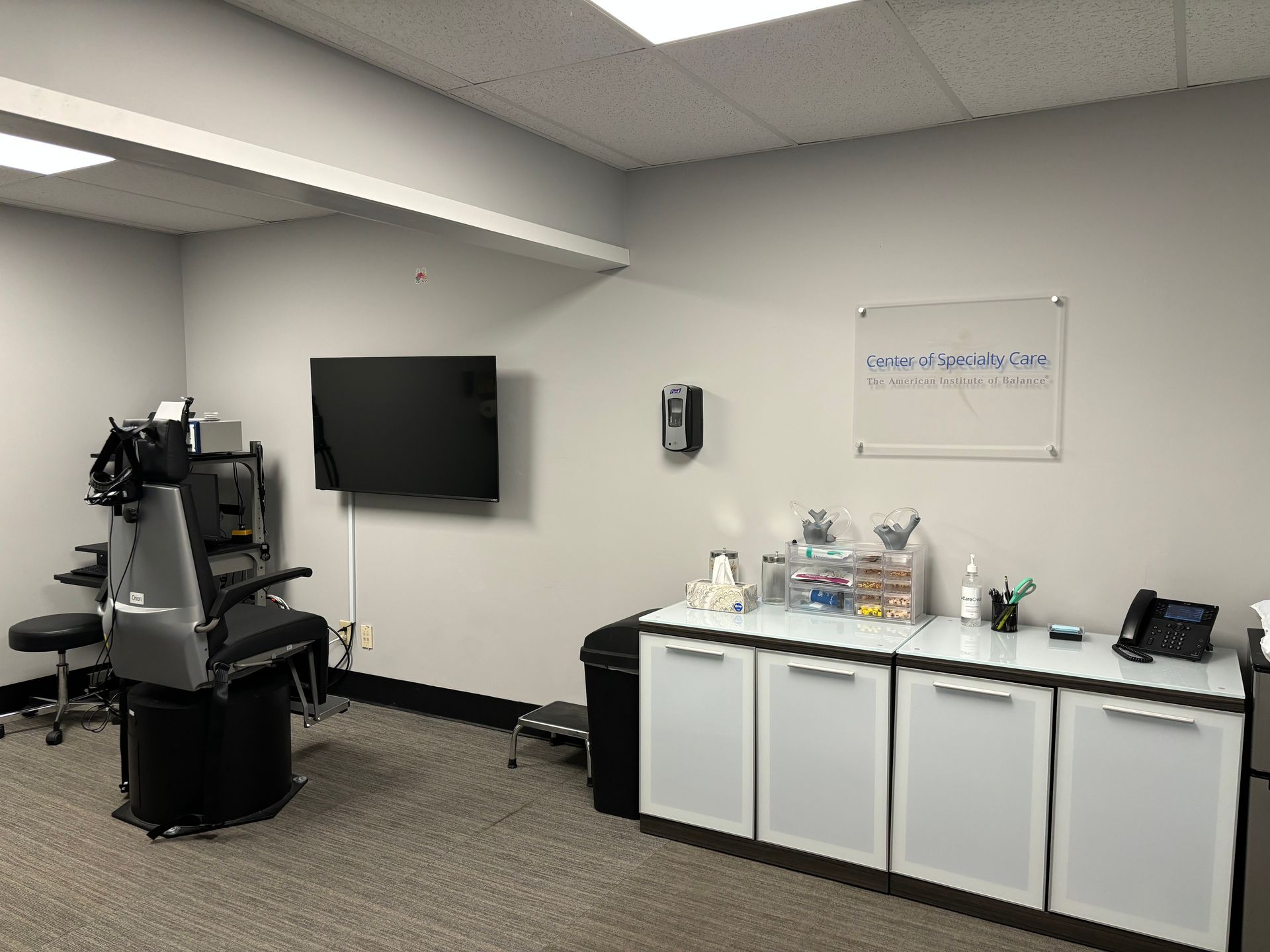 A room with a chair and a television on the wall.