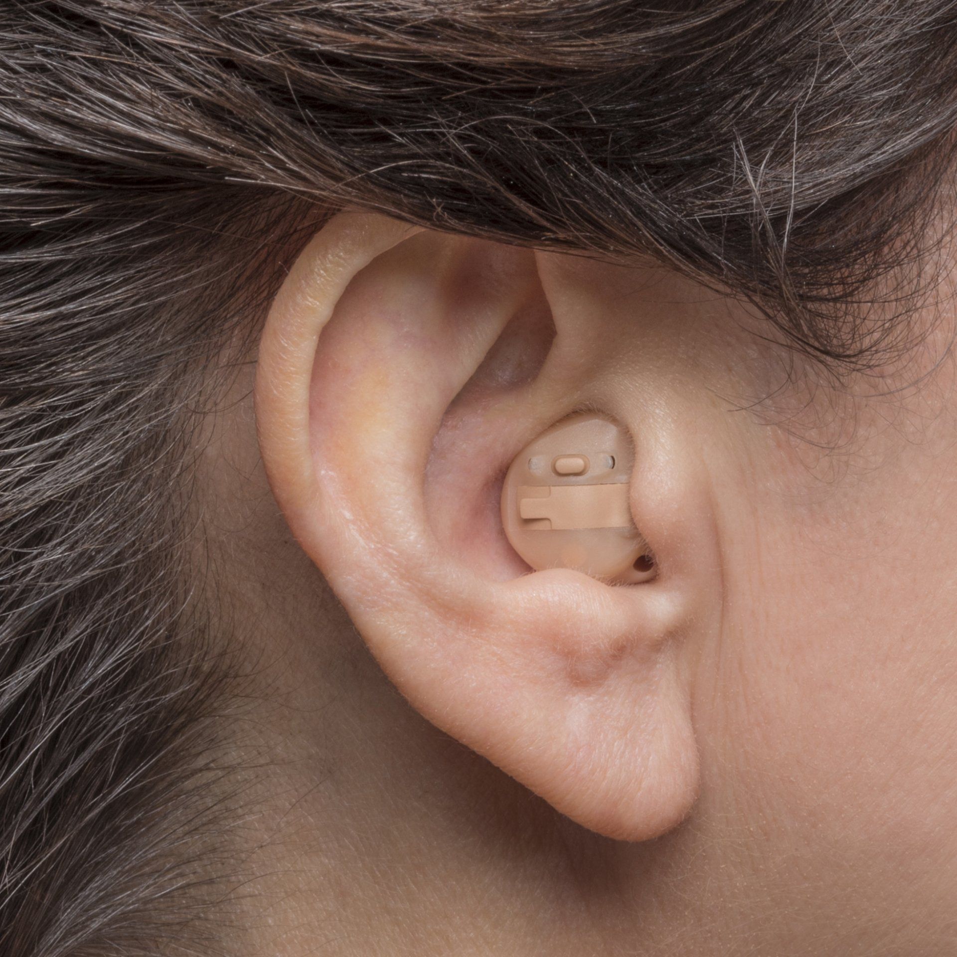 A close up of a person 's ear with a hearing aid in it