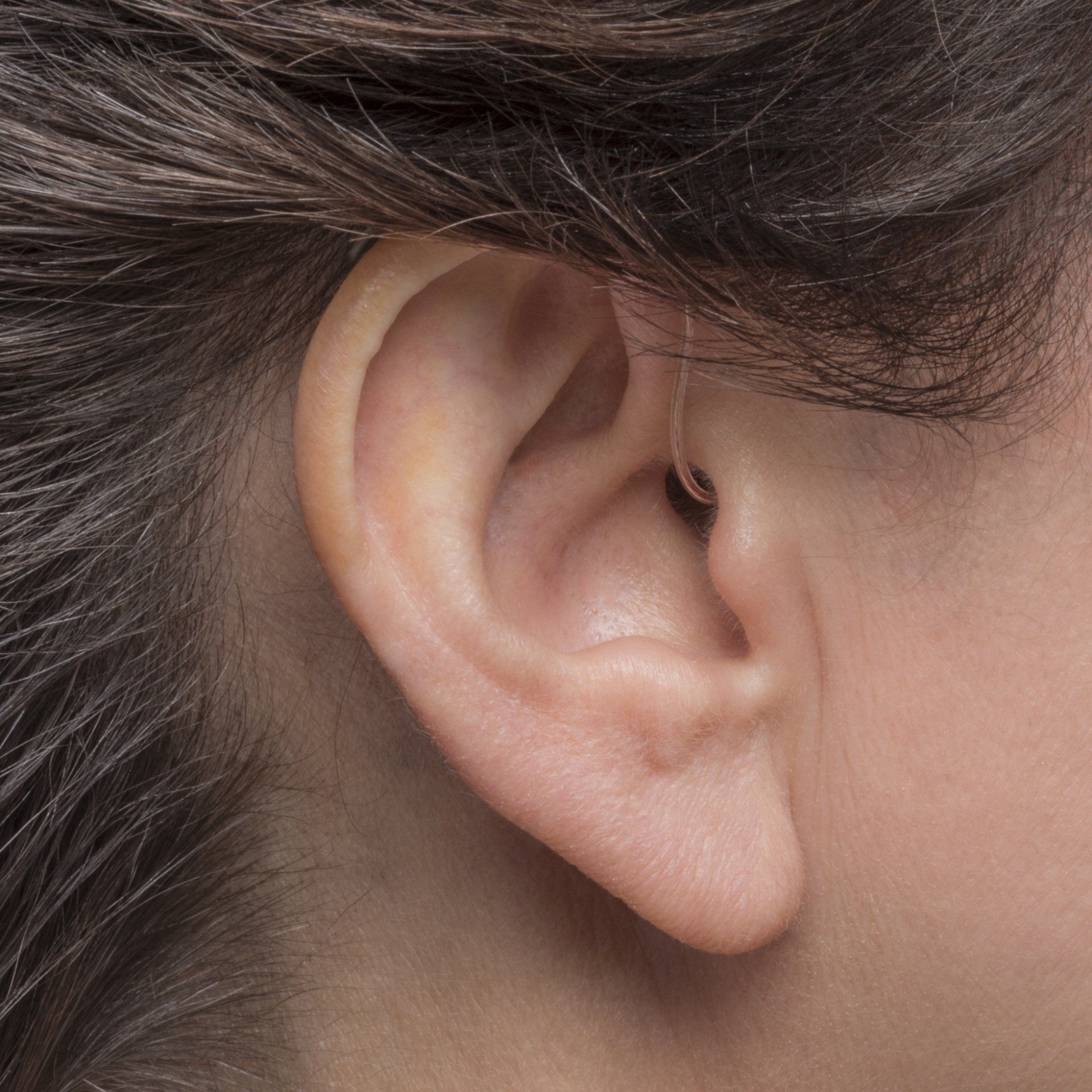 A close up of a woman 's ear with a hearing aid in it