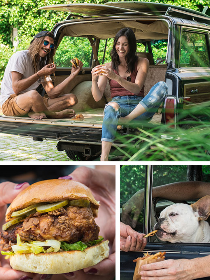A man and a woman are sitting in the back of a car eating hamburgers.