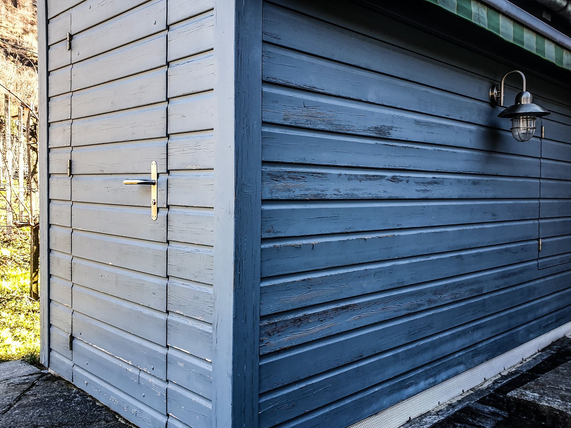 Un angolo di un deposito per attrezzi da giardino, blu e in legno