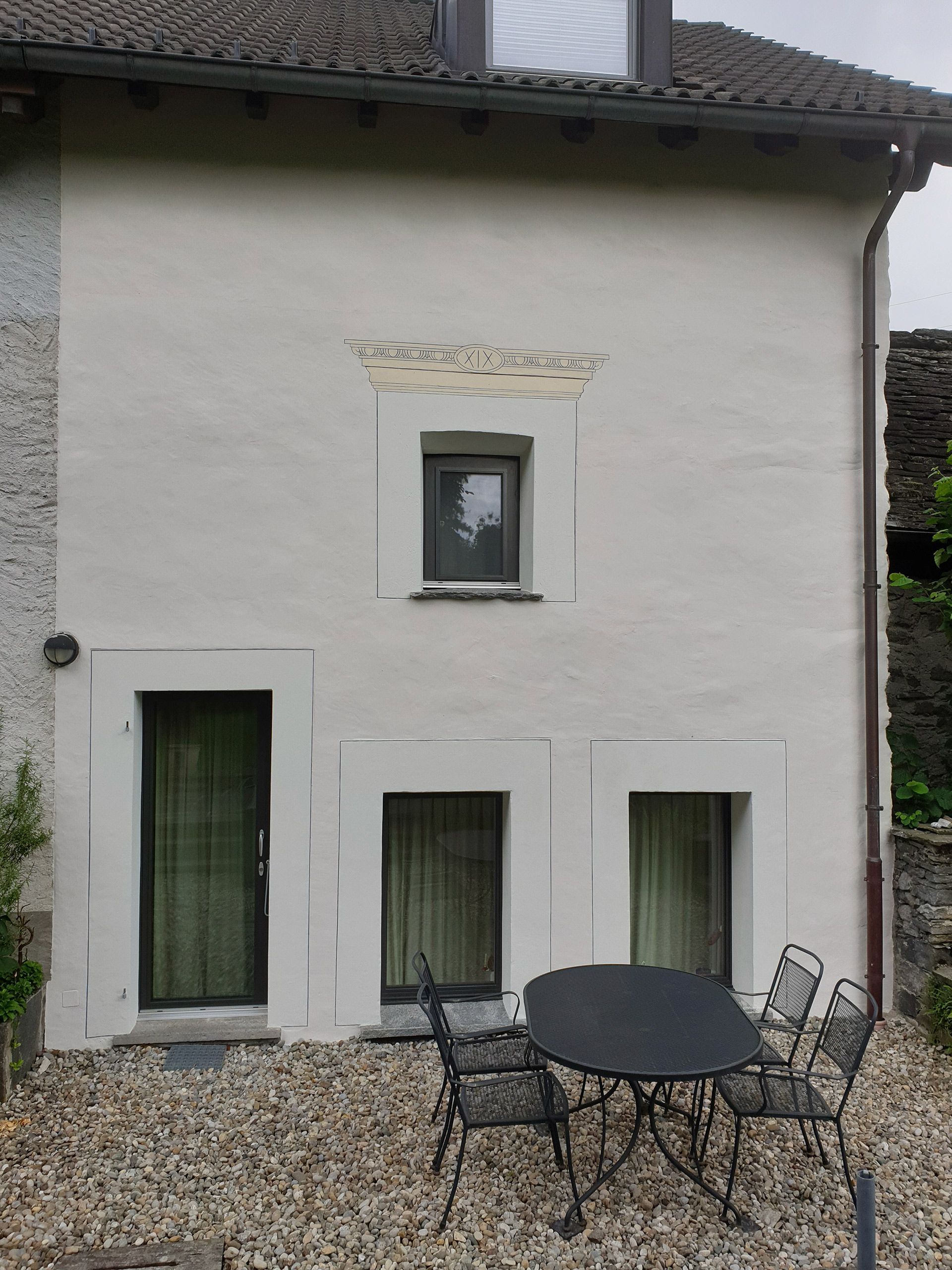 Una casa bianca con davanti un tavolo e delle sedie