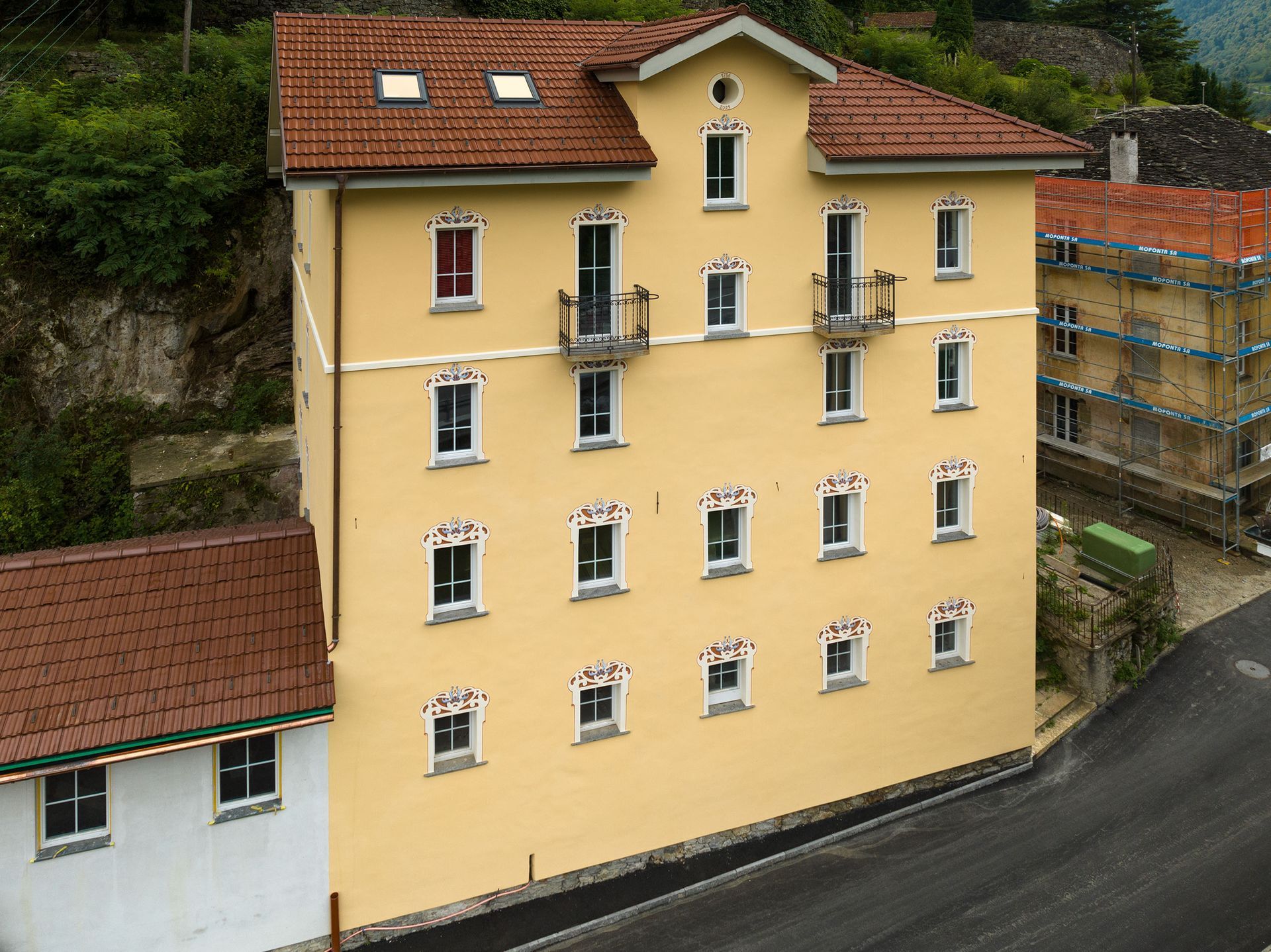 Un grande edificio giallo con un tetto di tegole rosse