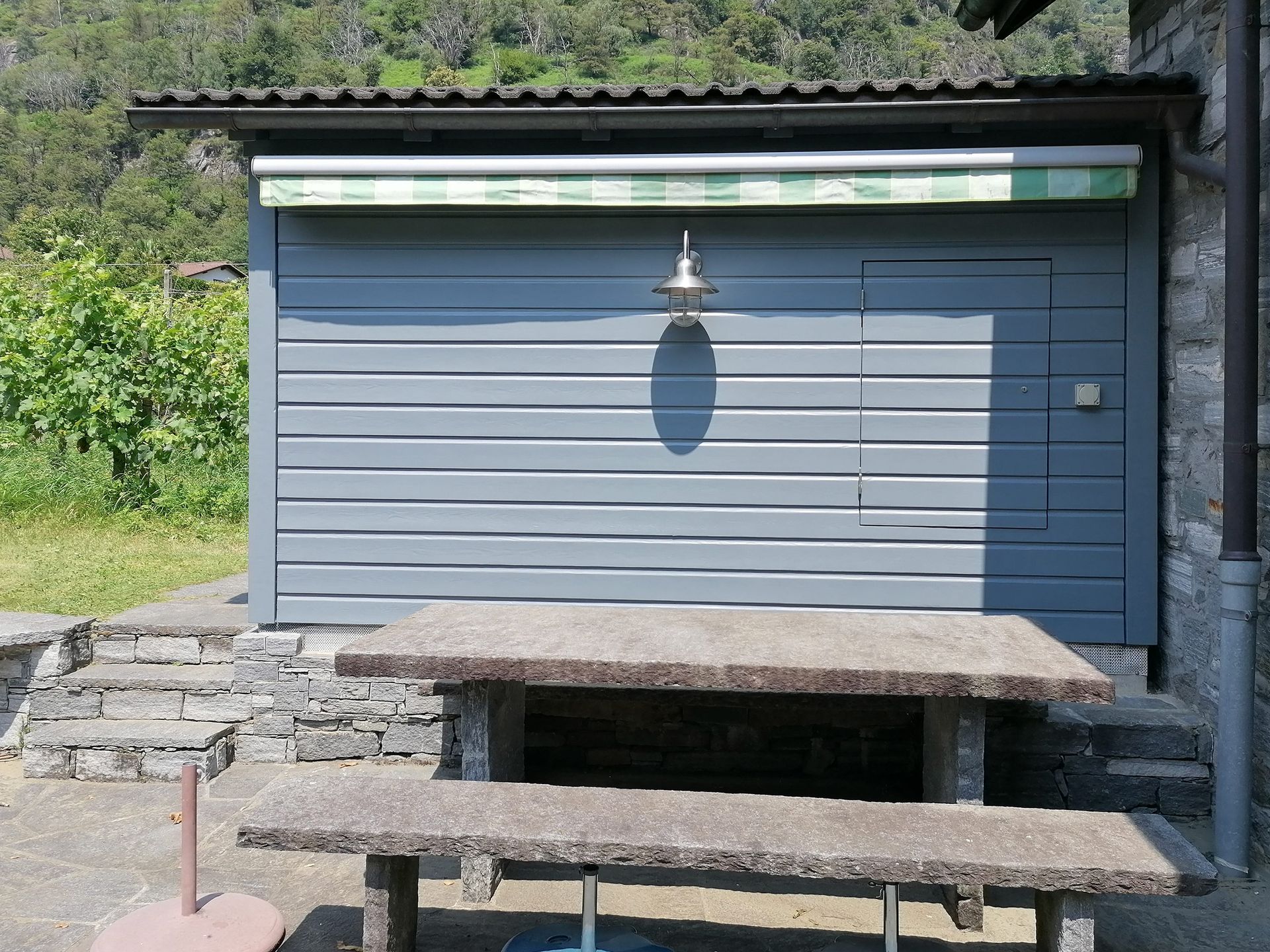 Una tettoia con davanti un tavolo in pietra