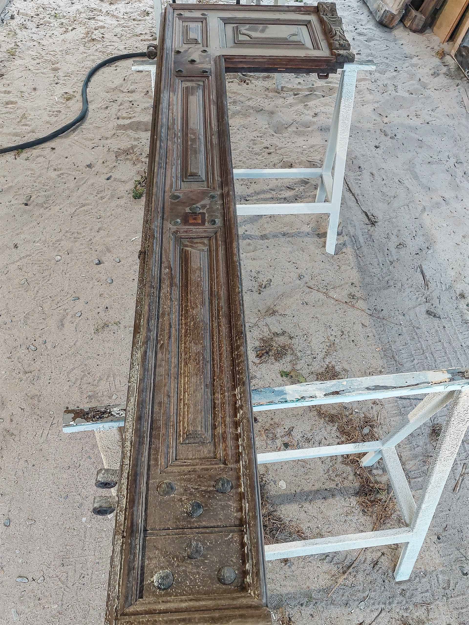 Un pezzo di legno è appoggiato sopra cavalletti in metallo.