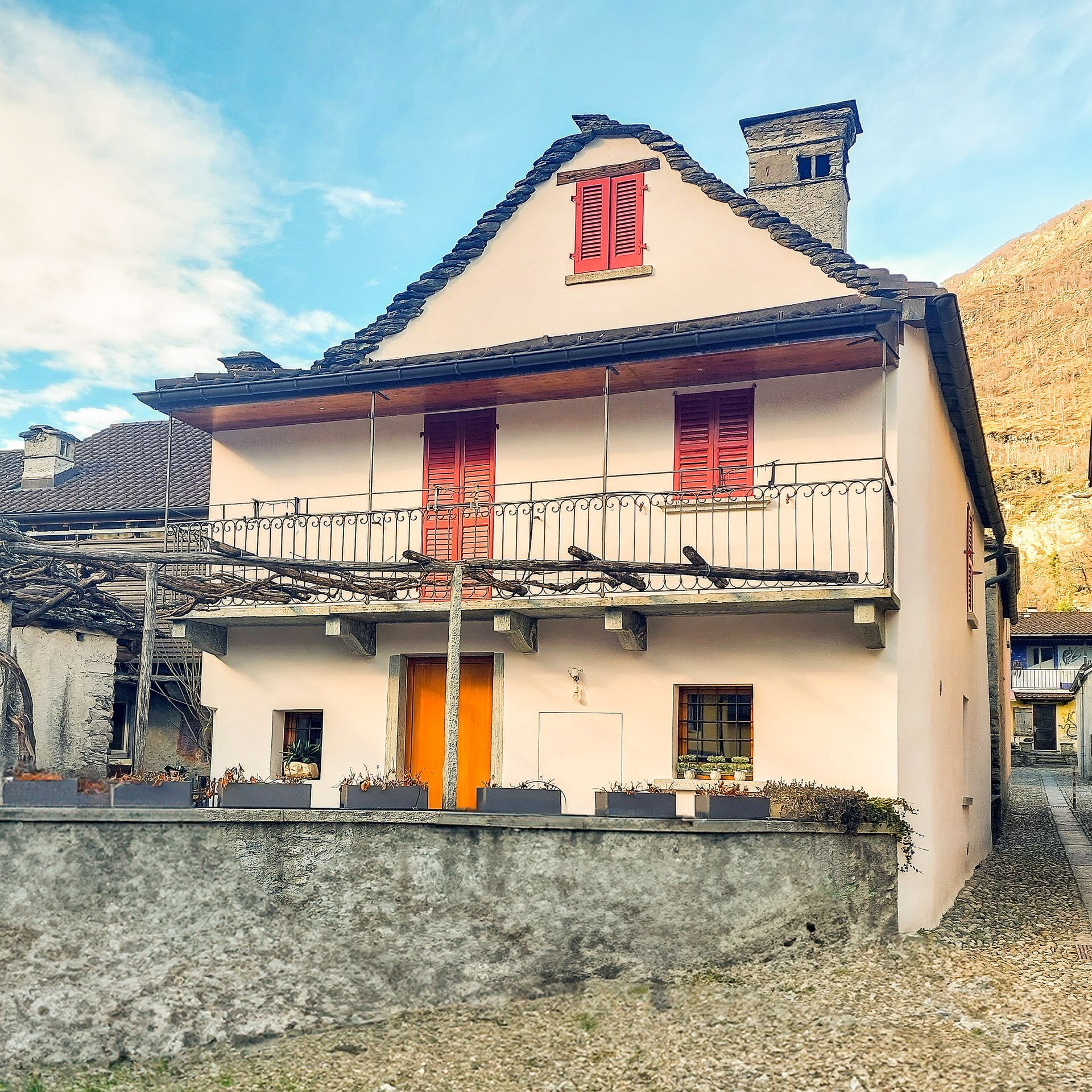 Una casa bianca con davanti un tavolo e delle sedie