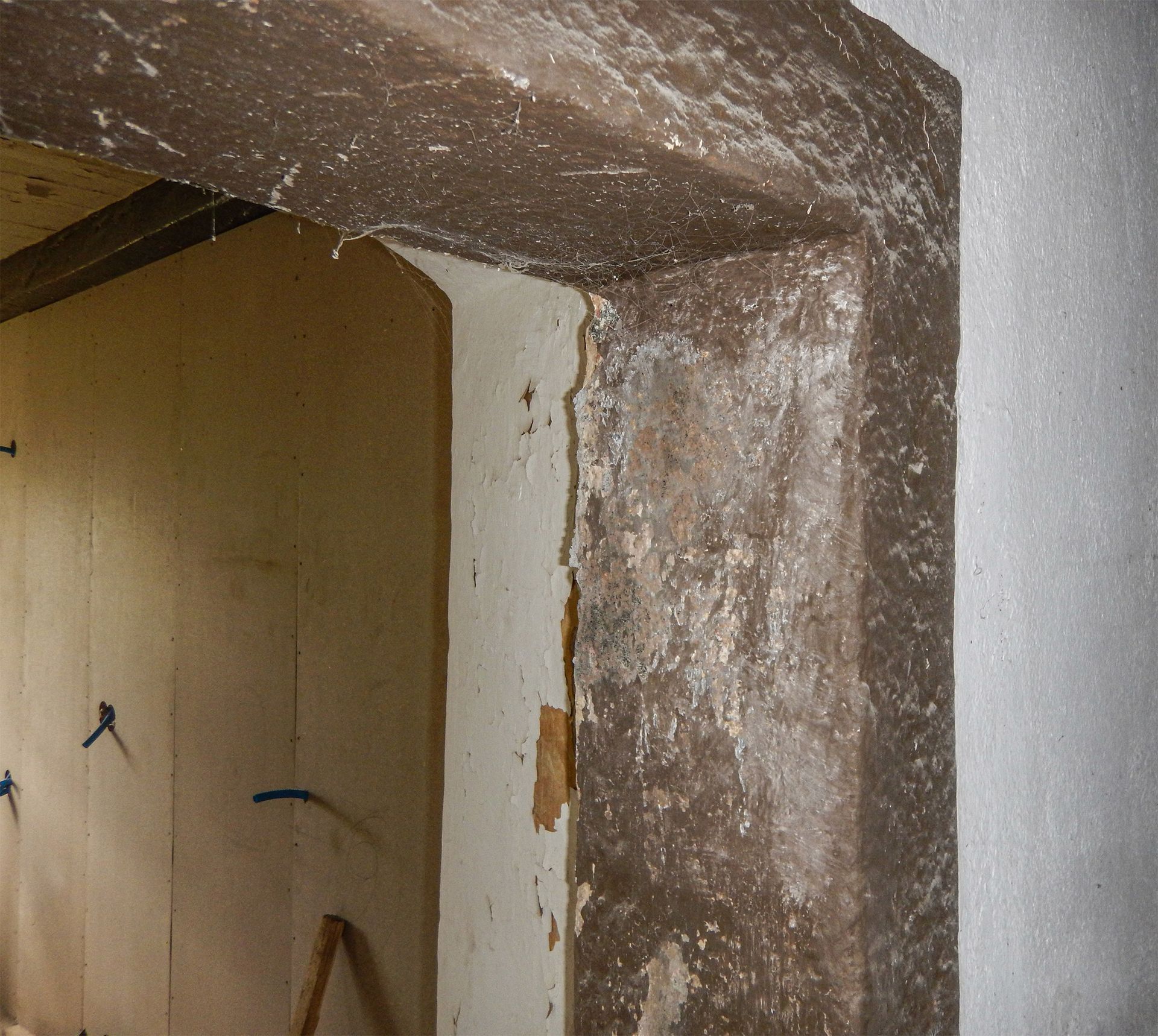 Un angolo di una stanza con una cornice in sasso marrone e un muro bianco