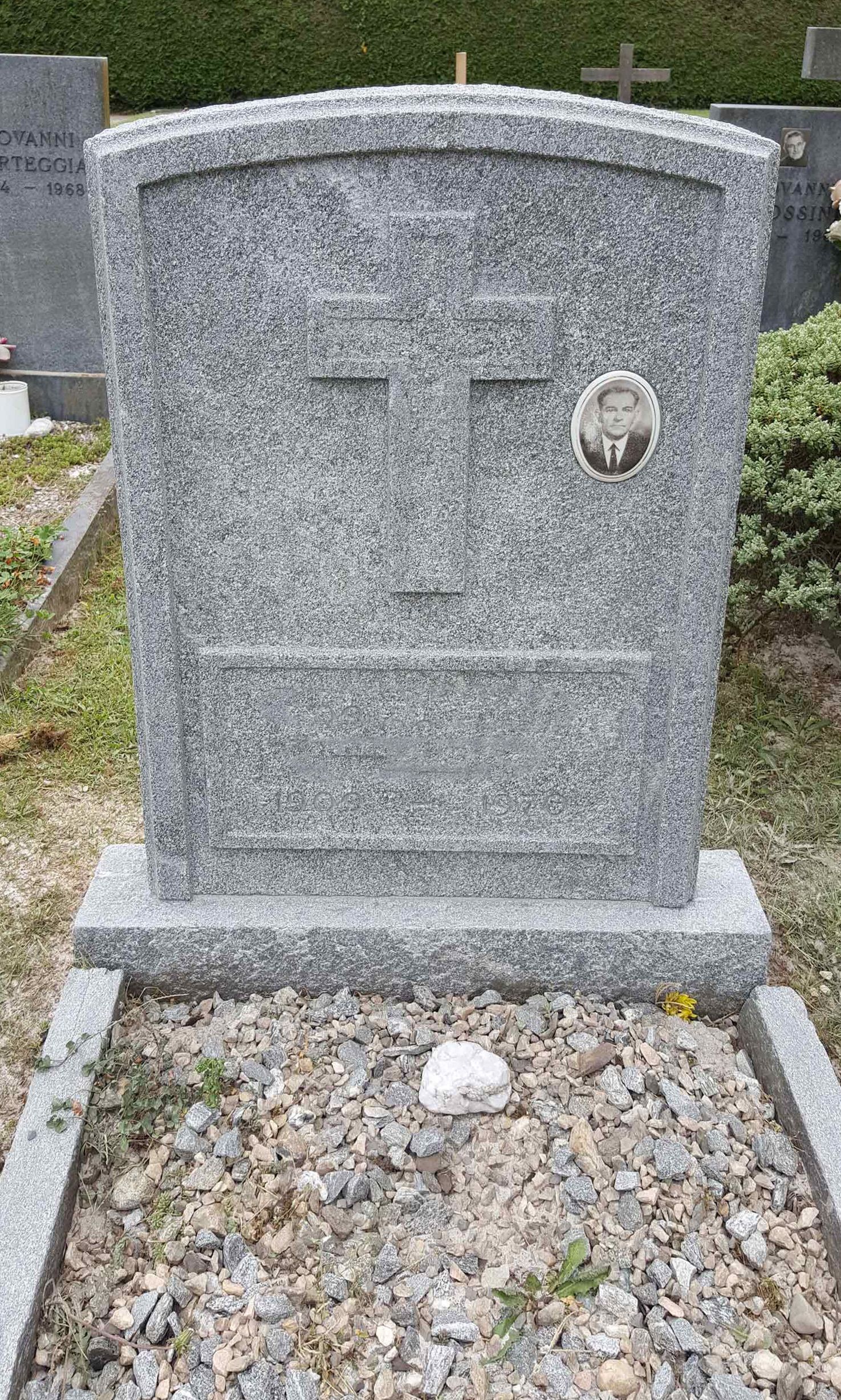 In un cimitero c'è una lapide con una croce sopra.