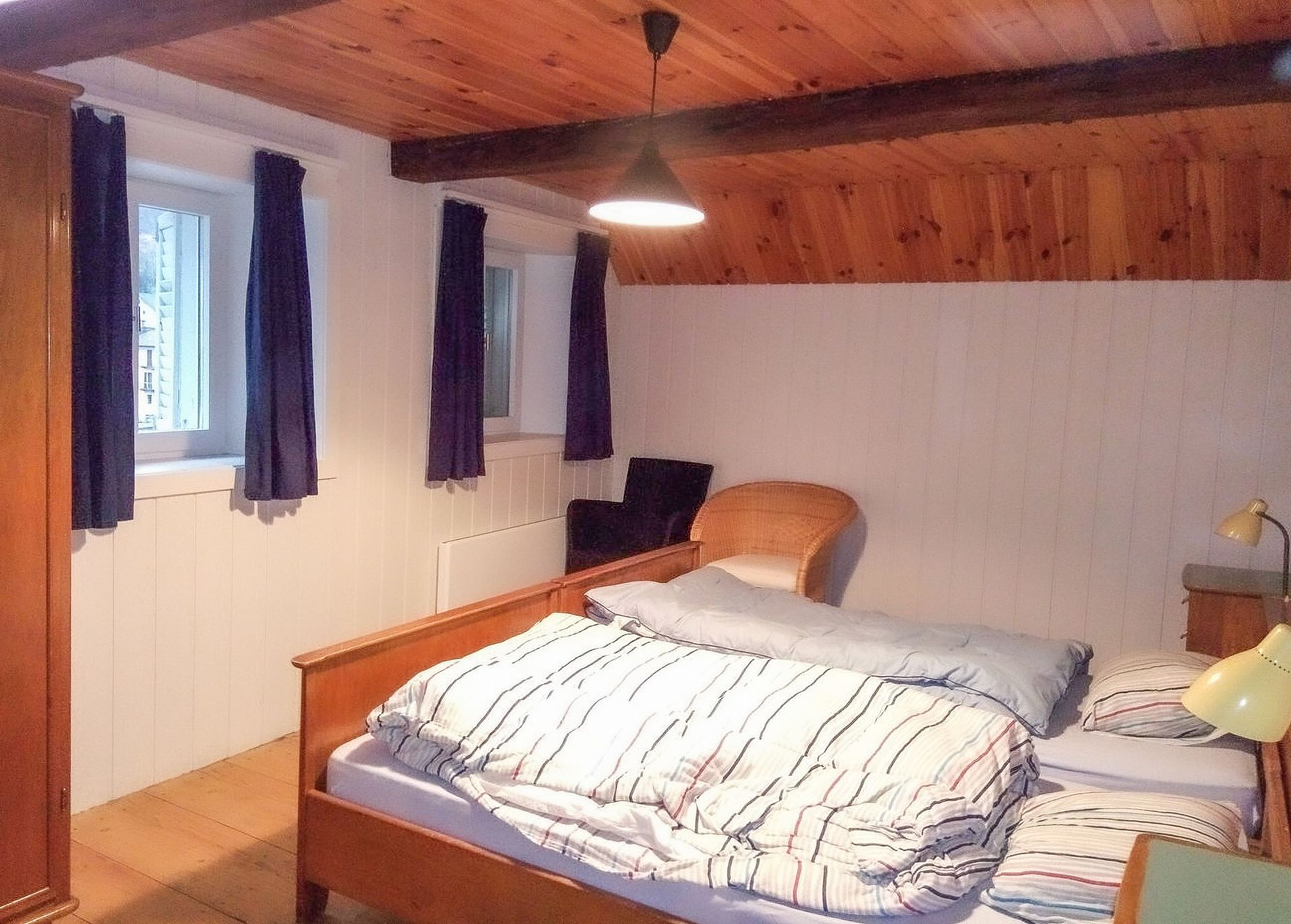 Una camera con due letti e una lampada a soffitto