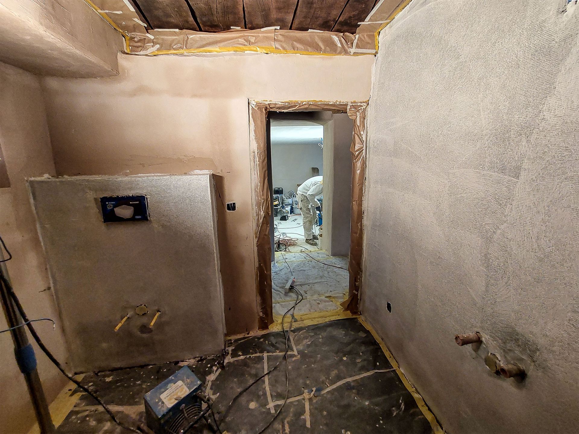 Una stanza con una porta e un muro in fase di ristrutturazione.