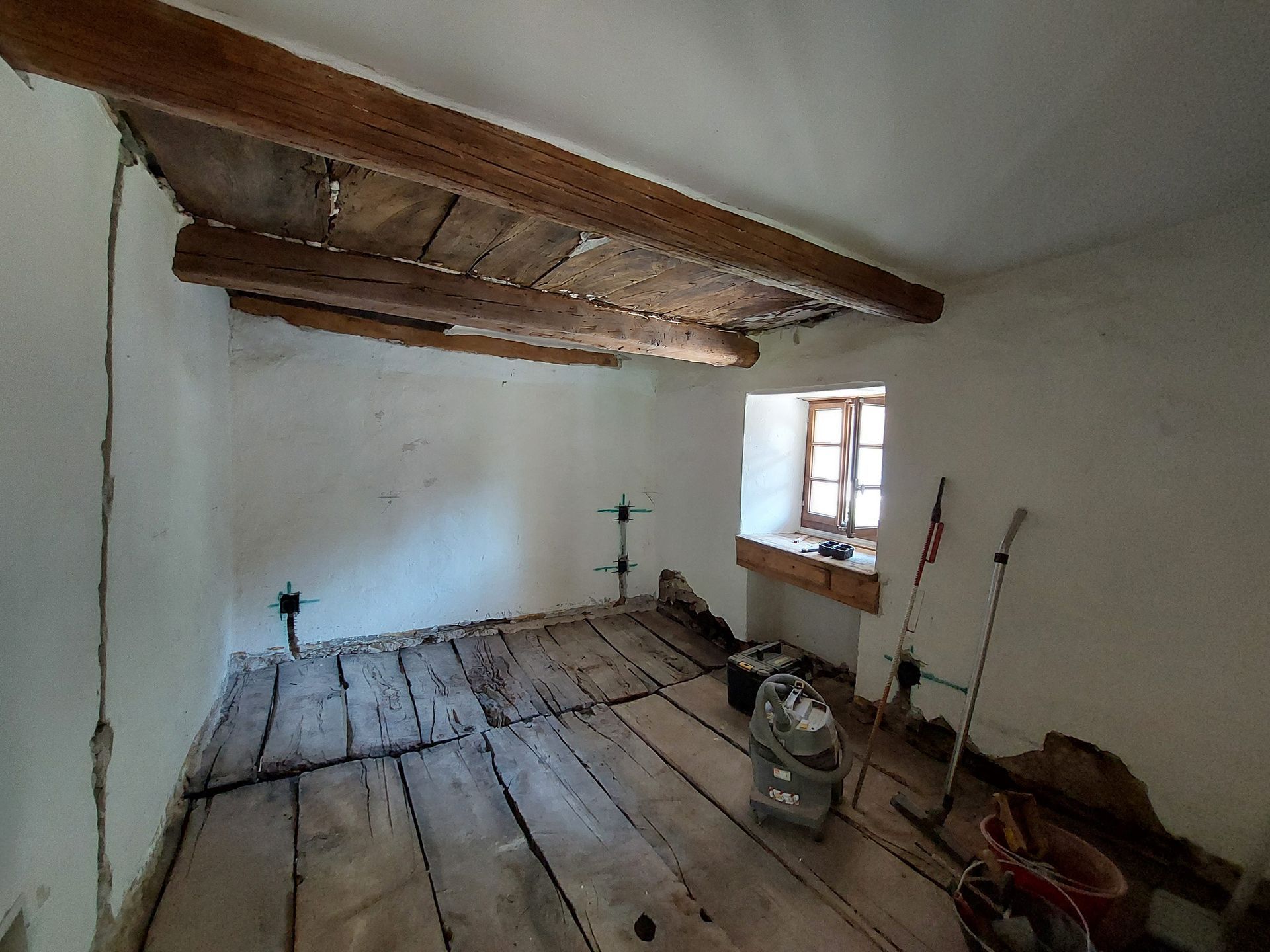 Una stanza con pavimento in legno e finestra