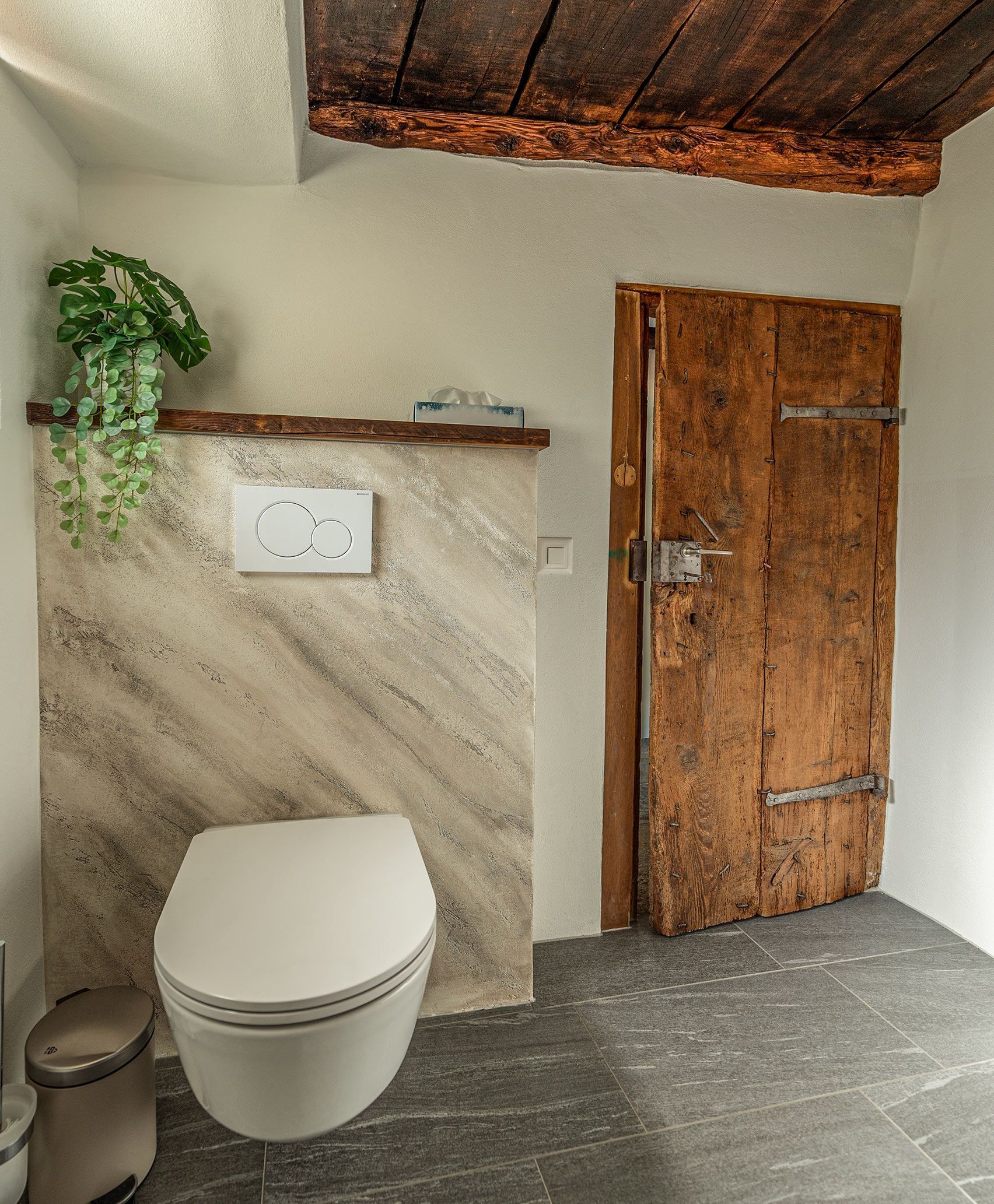 Un bagno con wc e porta in legno