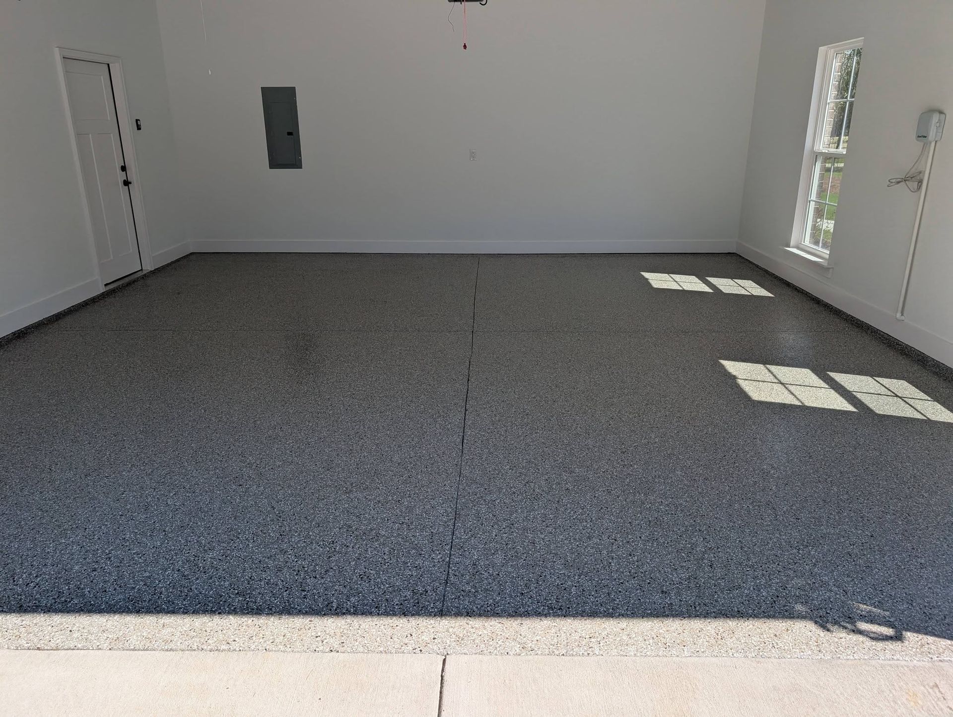 Empty carpeted room with white walls, doors, and sunlight from side windows