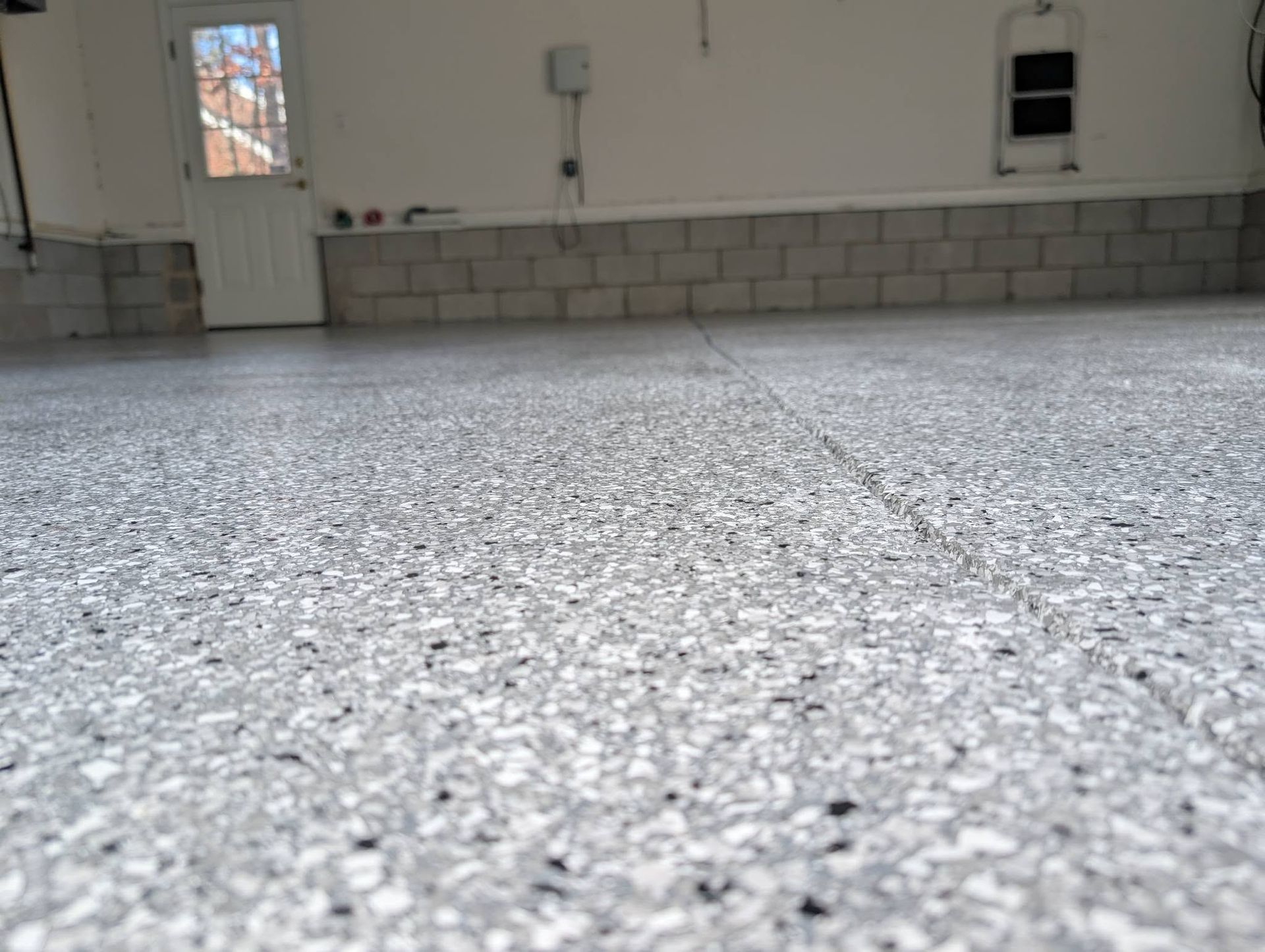 Empty garage with speckled floor and white walls