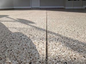 Sunlit concrete patio with a long shadow and a central expansion joint