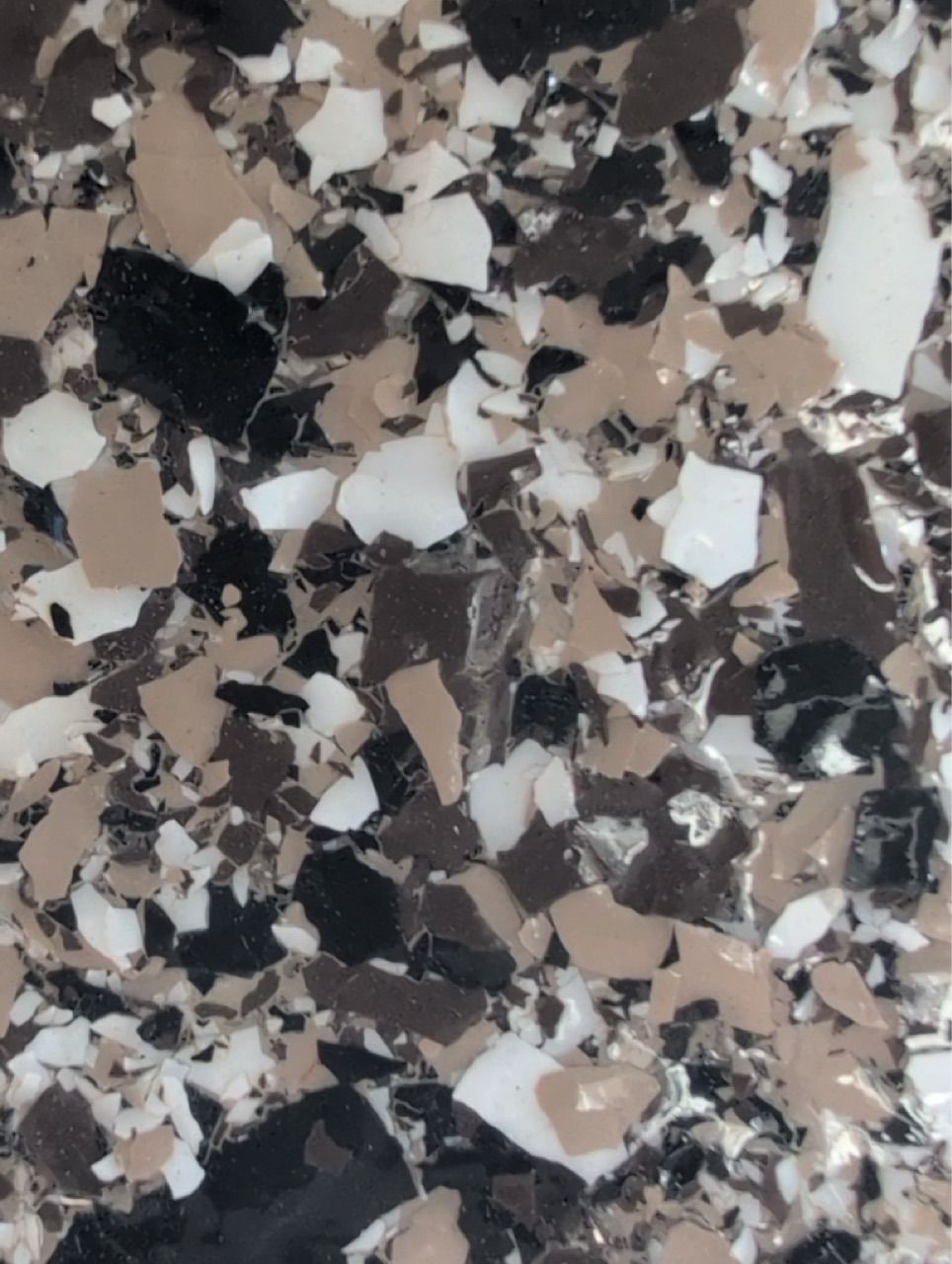 Abstract speckled stone or terrazzo surface in black, white, gray, and beige