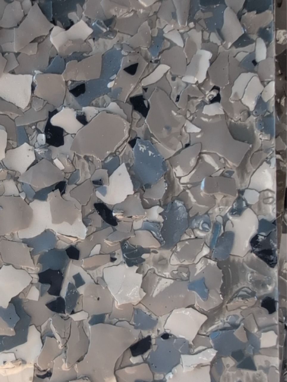 Abstract mosaic of broken gray, white, and blue tile fragments
