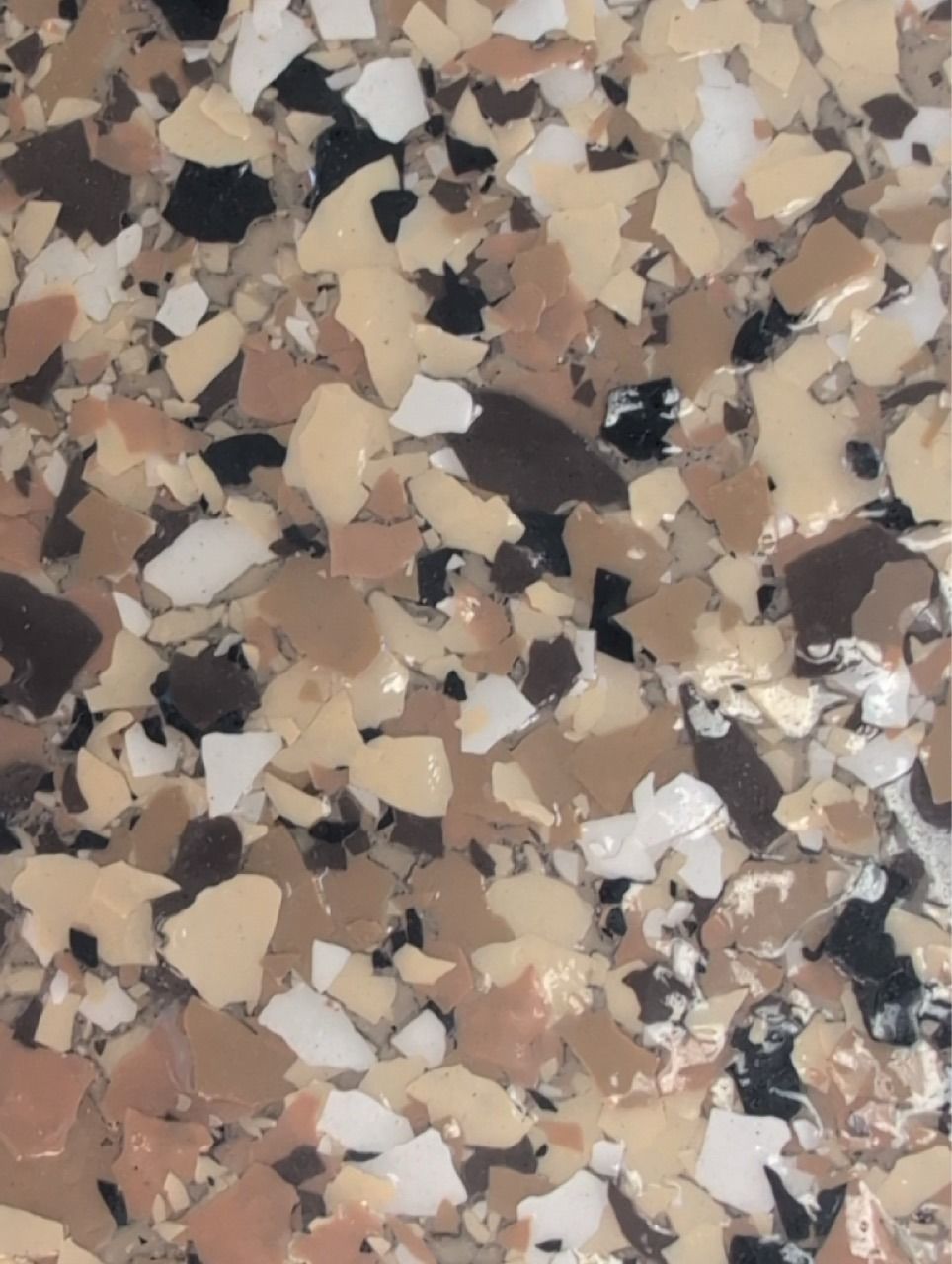 Close-up of speckled beige, brown, black, and white terrazzo stone surface