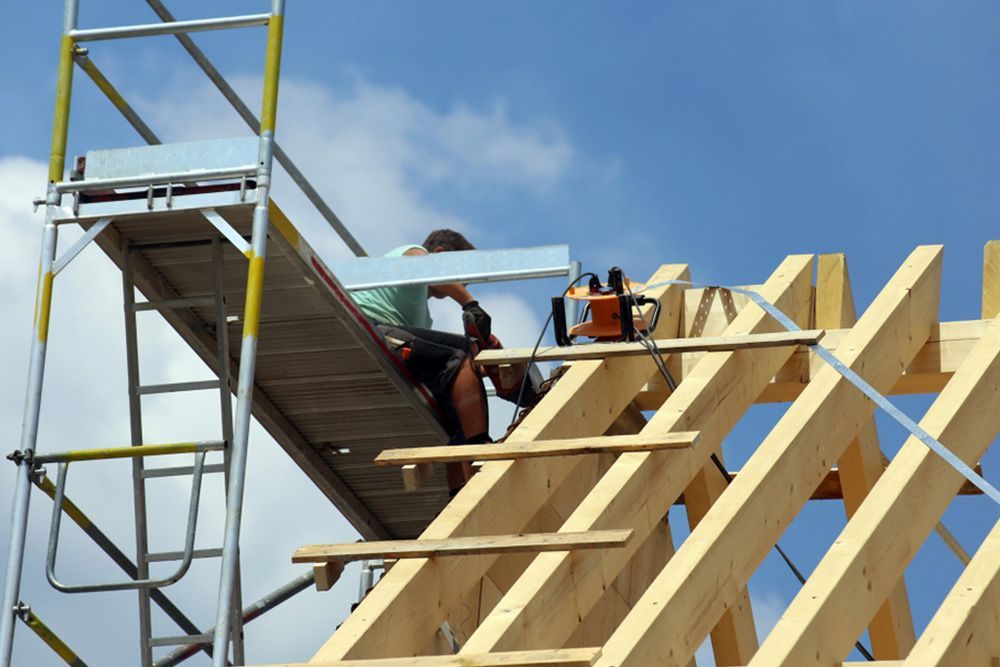 Man Using Scaffolding to Finish the House Roof — Builder in Deepwater, QLD