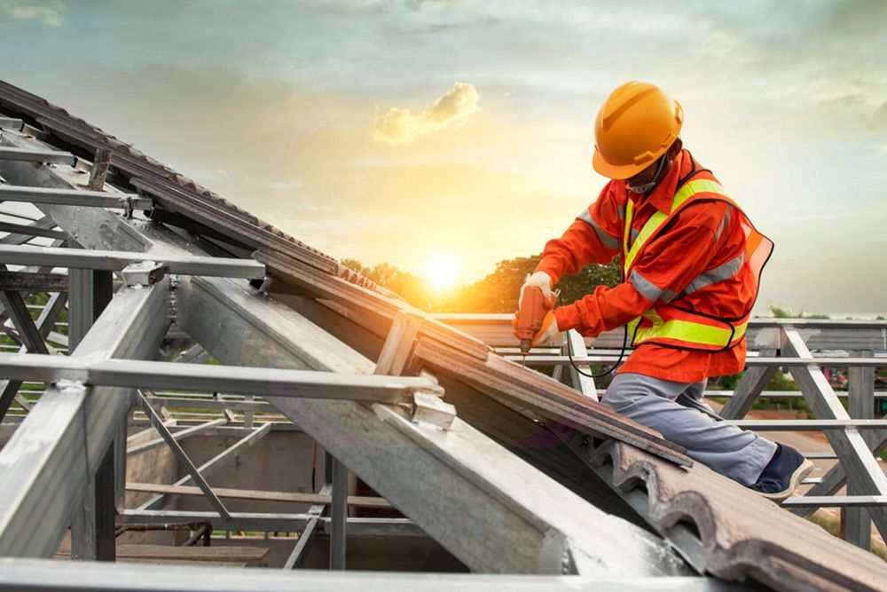 Man Using Automatic Driller at the Top of the House — Builder in Deepwater, QLD