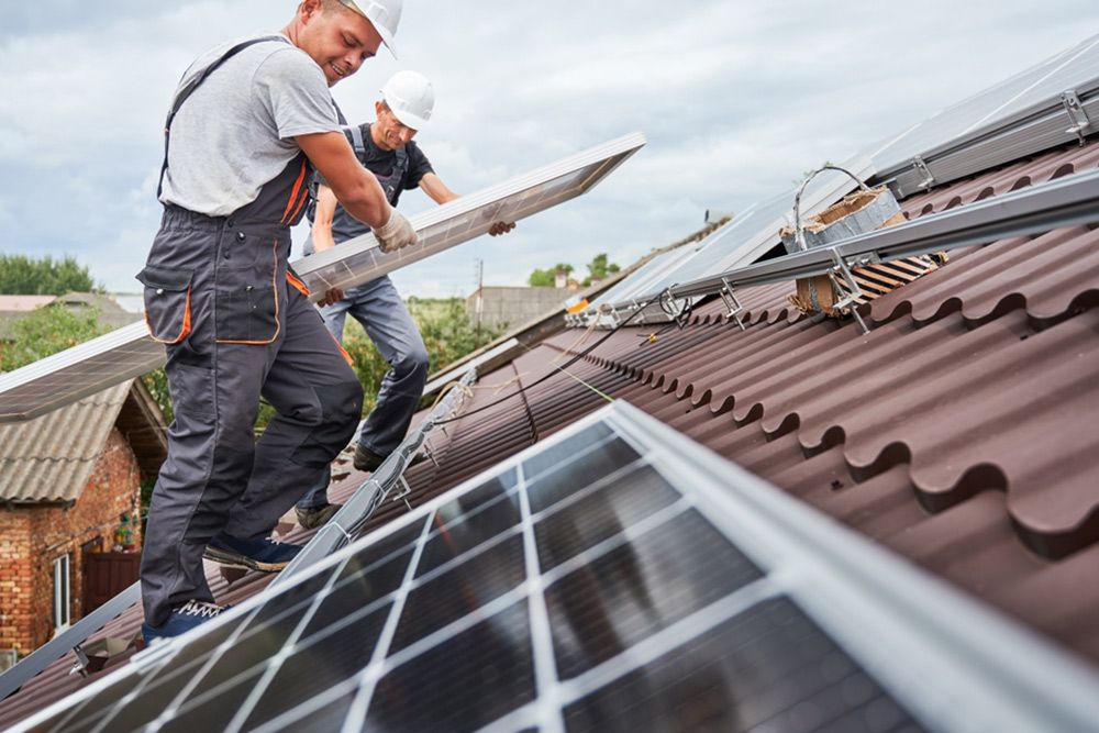 2 Man Placing a Solar Energy Power at the Top of the Roof — Builder in Lowmead, QLD