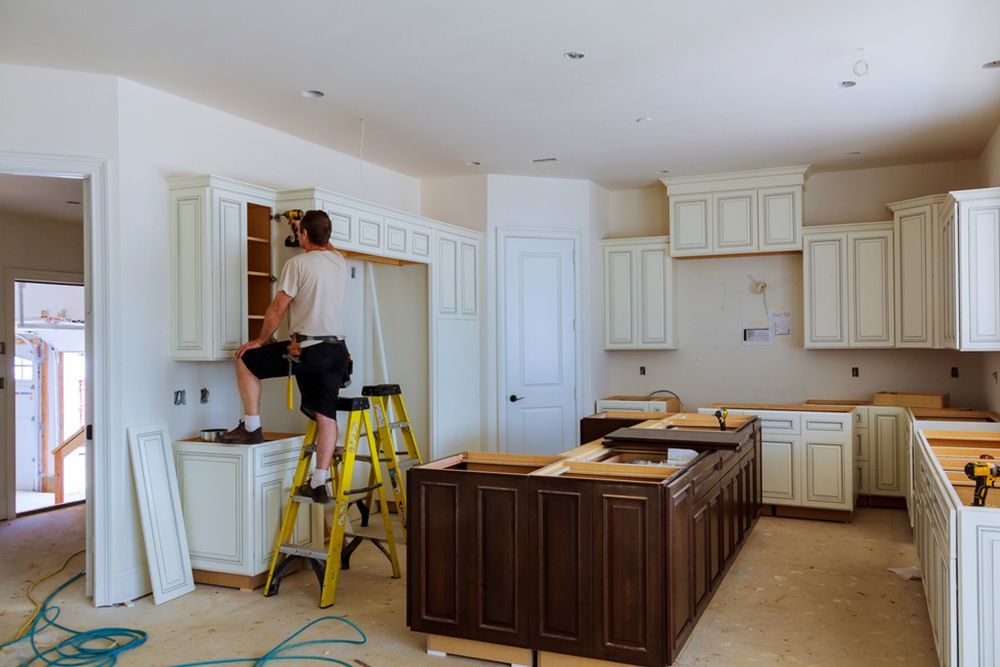 Man using electric drill to renovate the kitchen — Kitchen Renovation in Gladstone Region, QLD
