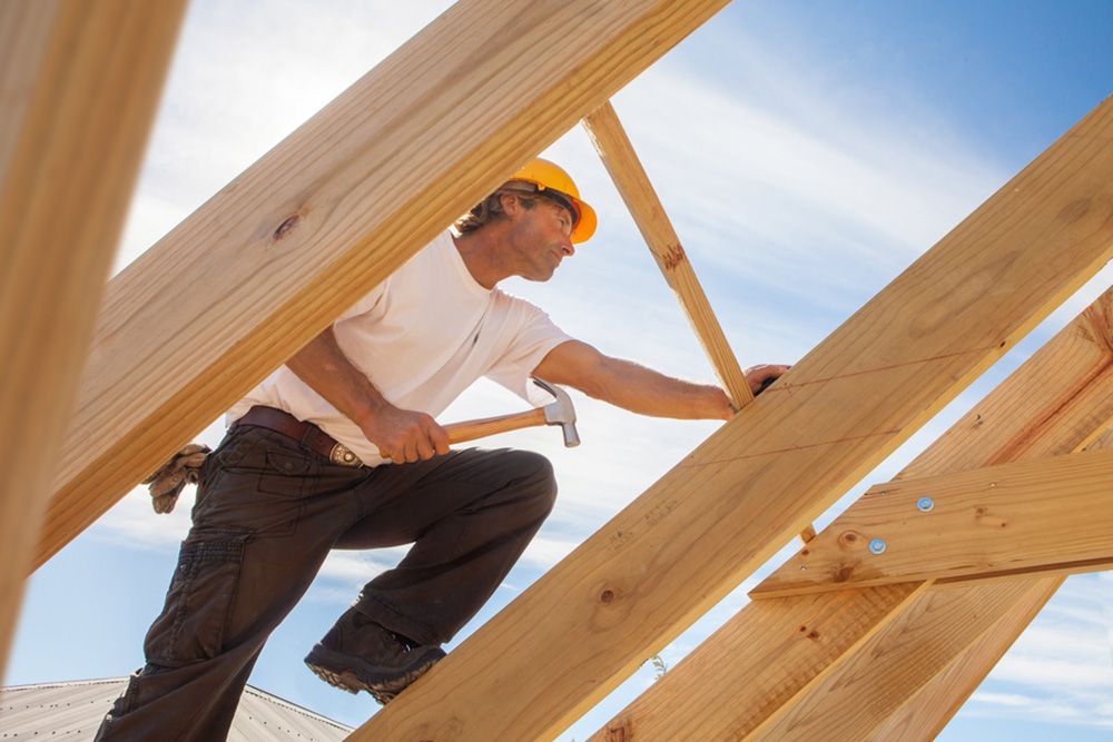 Man Carrying a Hammer in the Roof — Builder in Rosedale, QLD