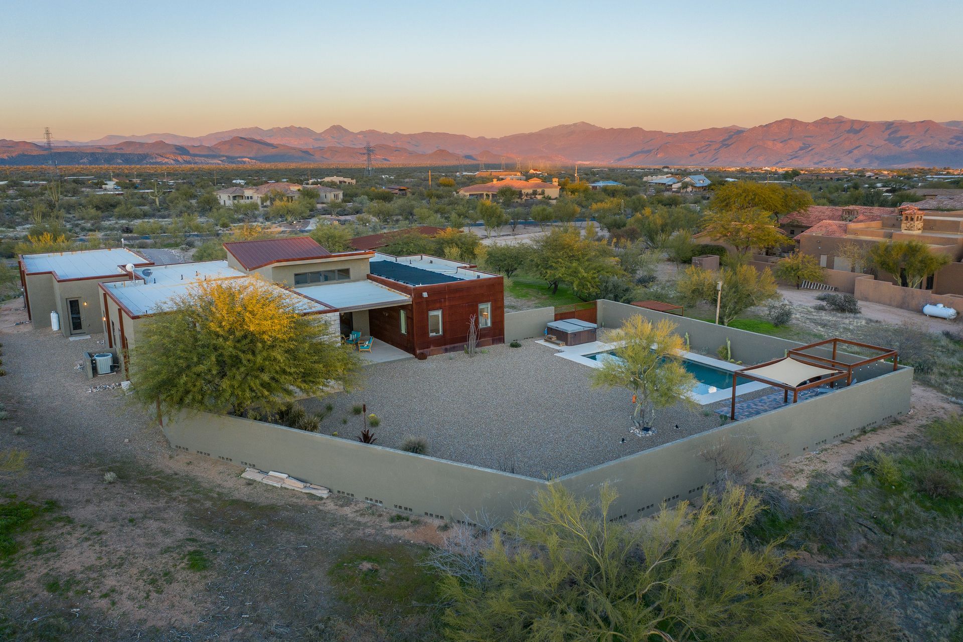 An aerial view of a house with a pool and mountains in the background.