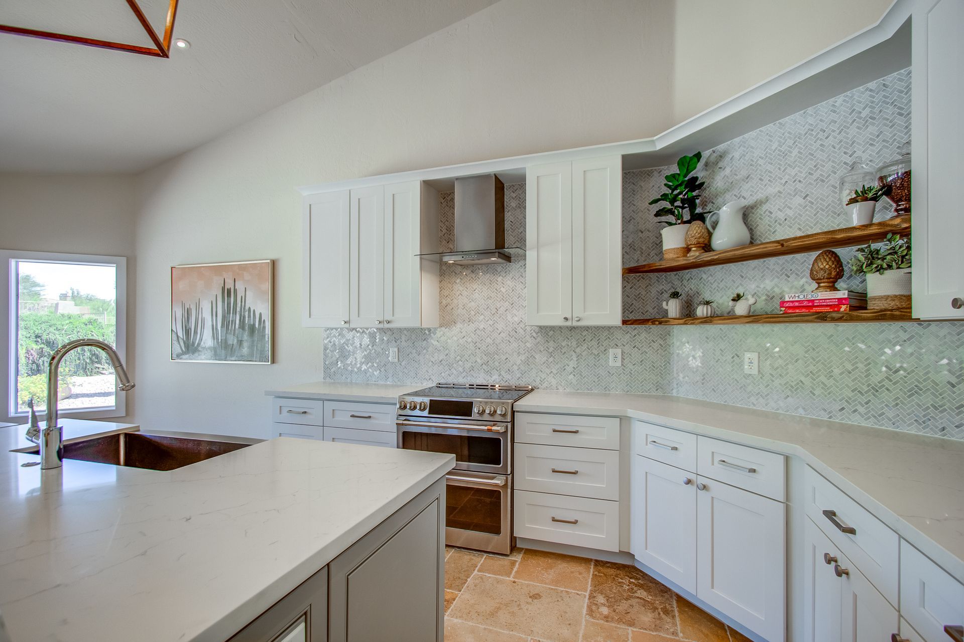 A kitchen with white cabinets , stainless steel appliances , a sink , and a large island.