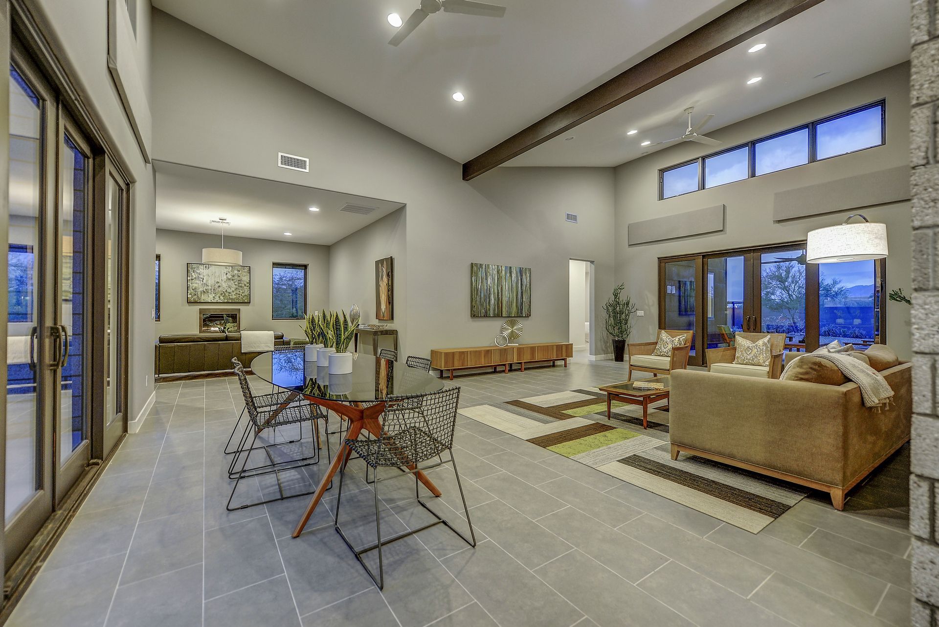 A living room with a couch , table , chairs and a ceiling fan.