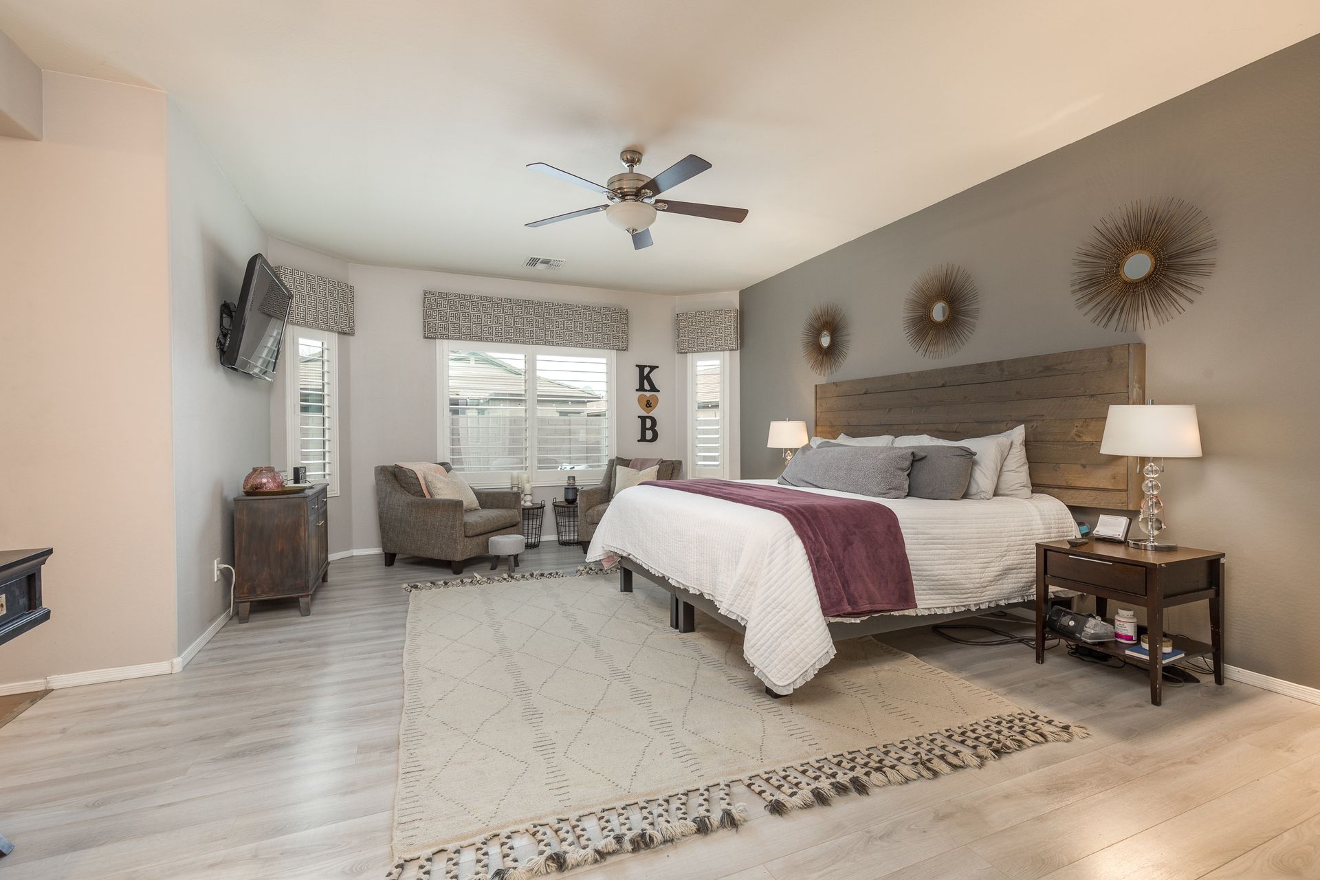 A bedroom with a large bed and a ceiling fan