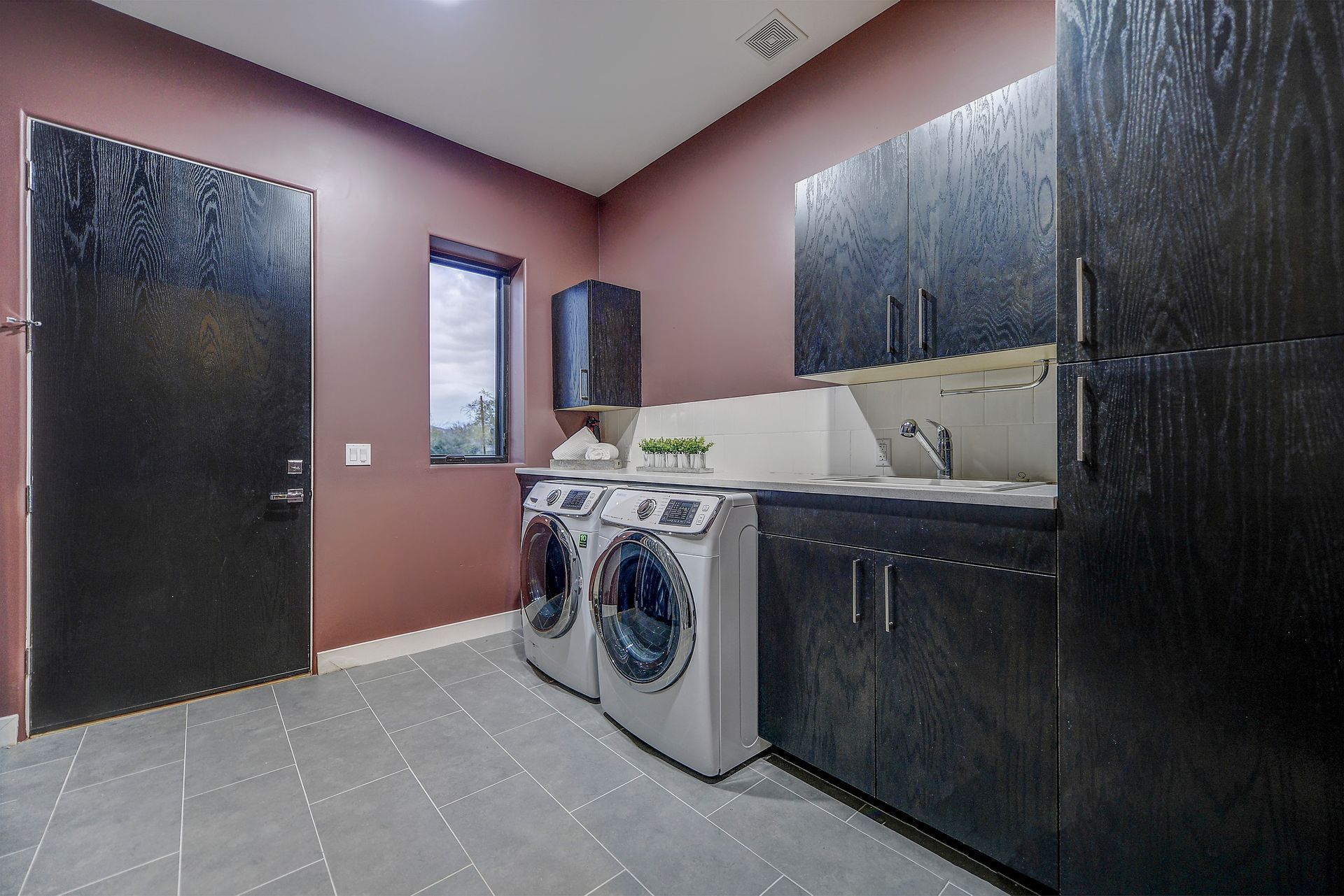 A laundry room with a washer and dryer and a sink.