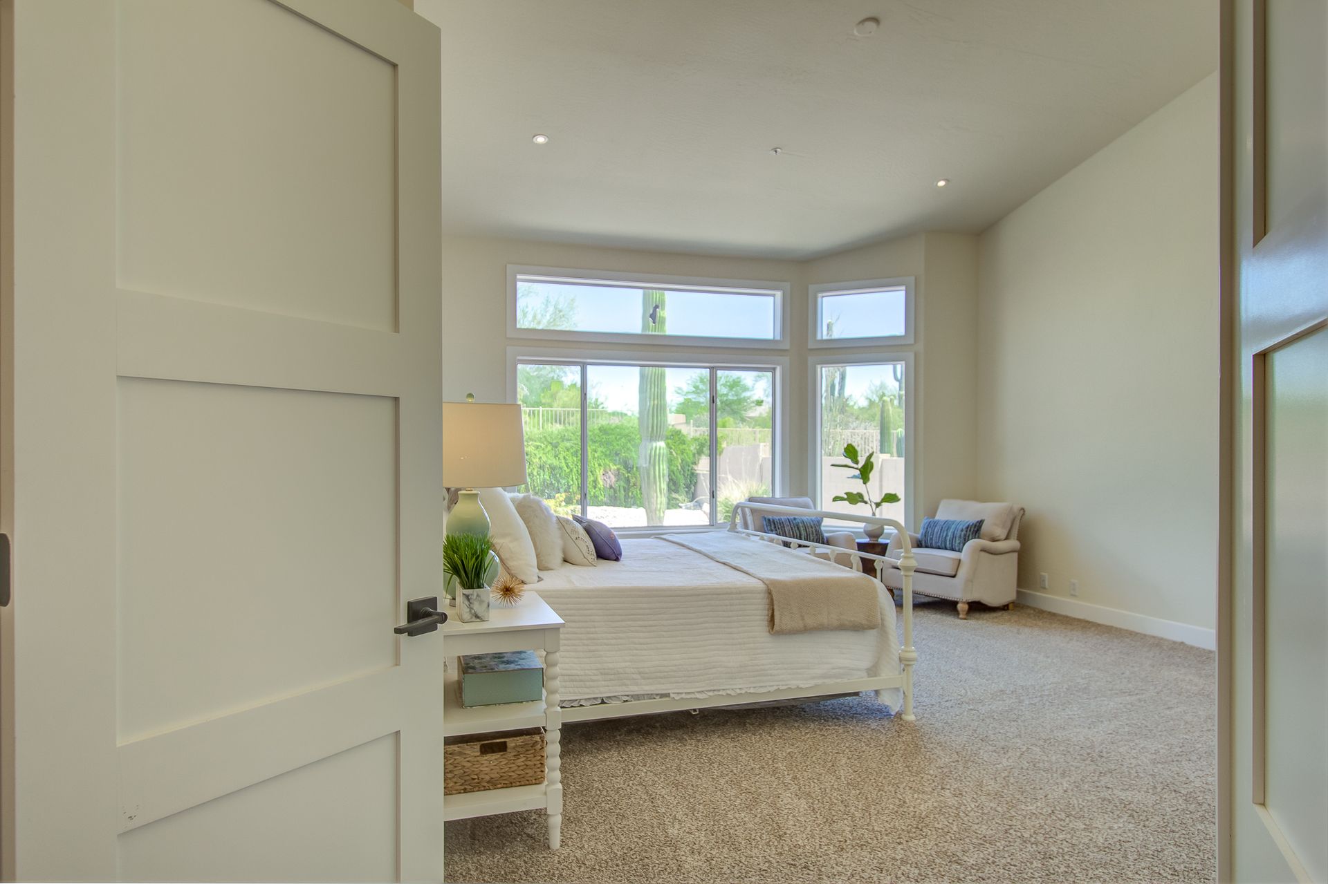 A bedroom with a king size bed and a large window.