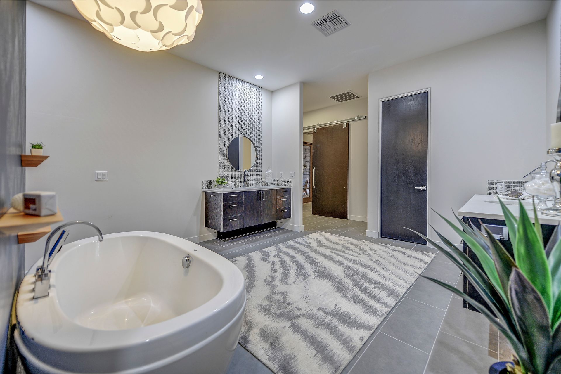 A bathroom with a bathtub , sinks , and a rug.