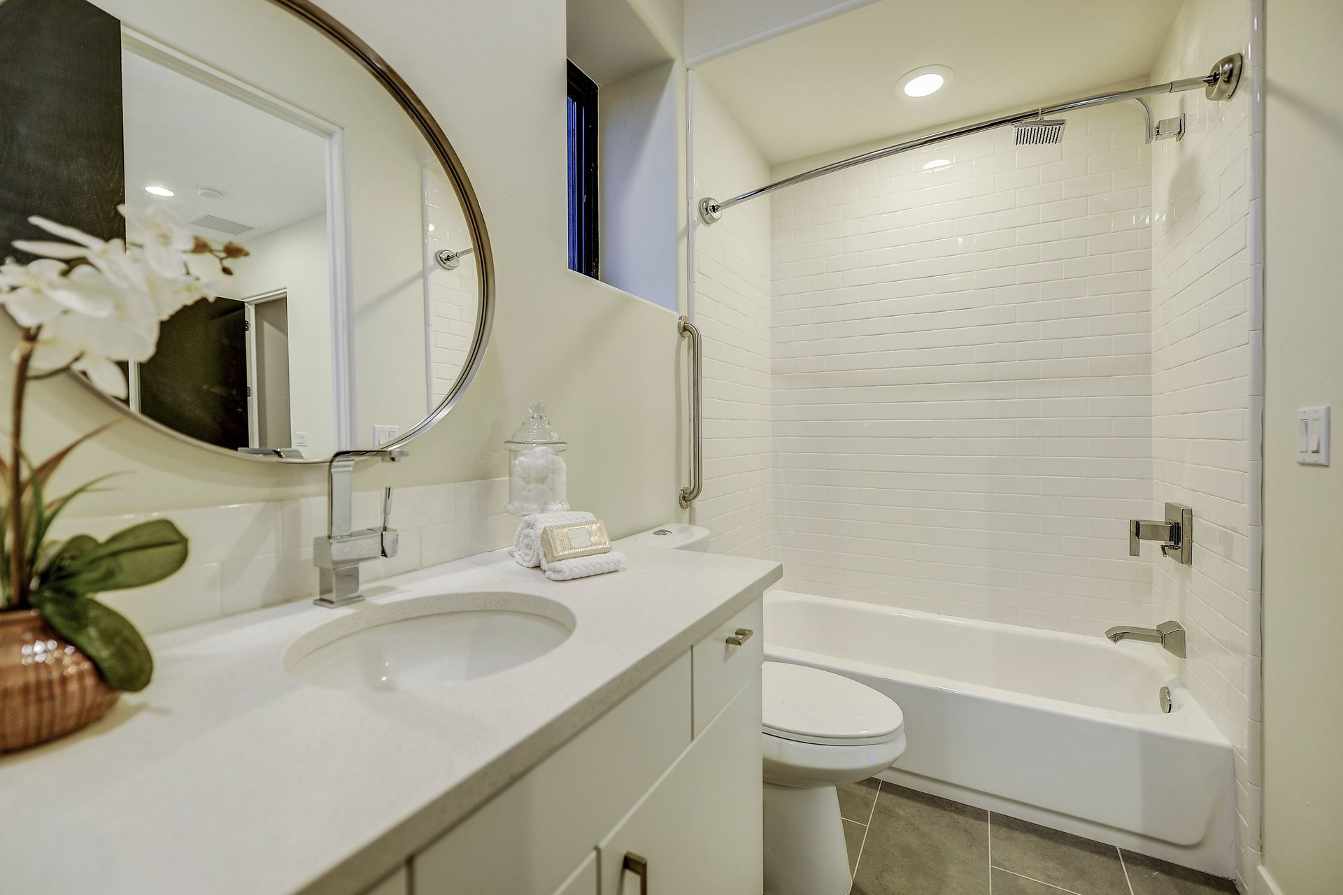 A bathroom with a sink , toilet , tub and mirror.
