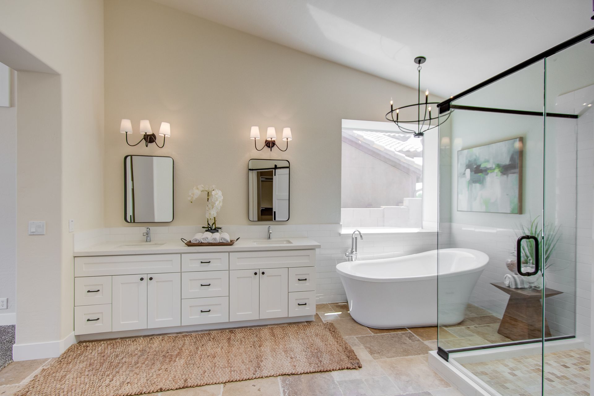 A bathroom with two sinks , a tub , and a walk in shower.