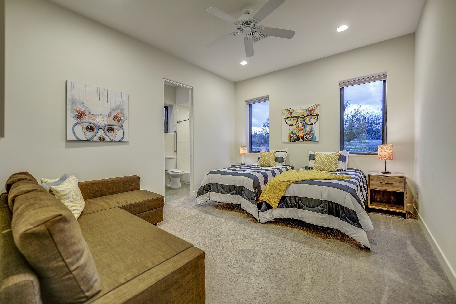 A bedroom with two beds , a couch , and a ceiling fan.