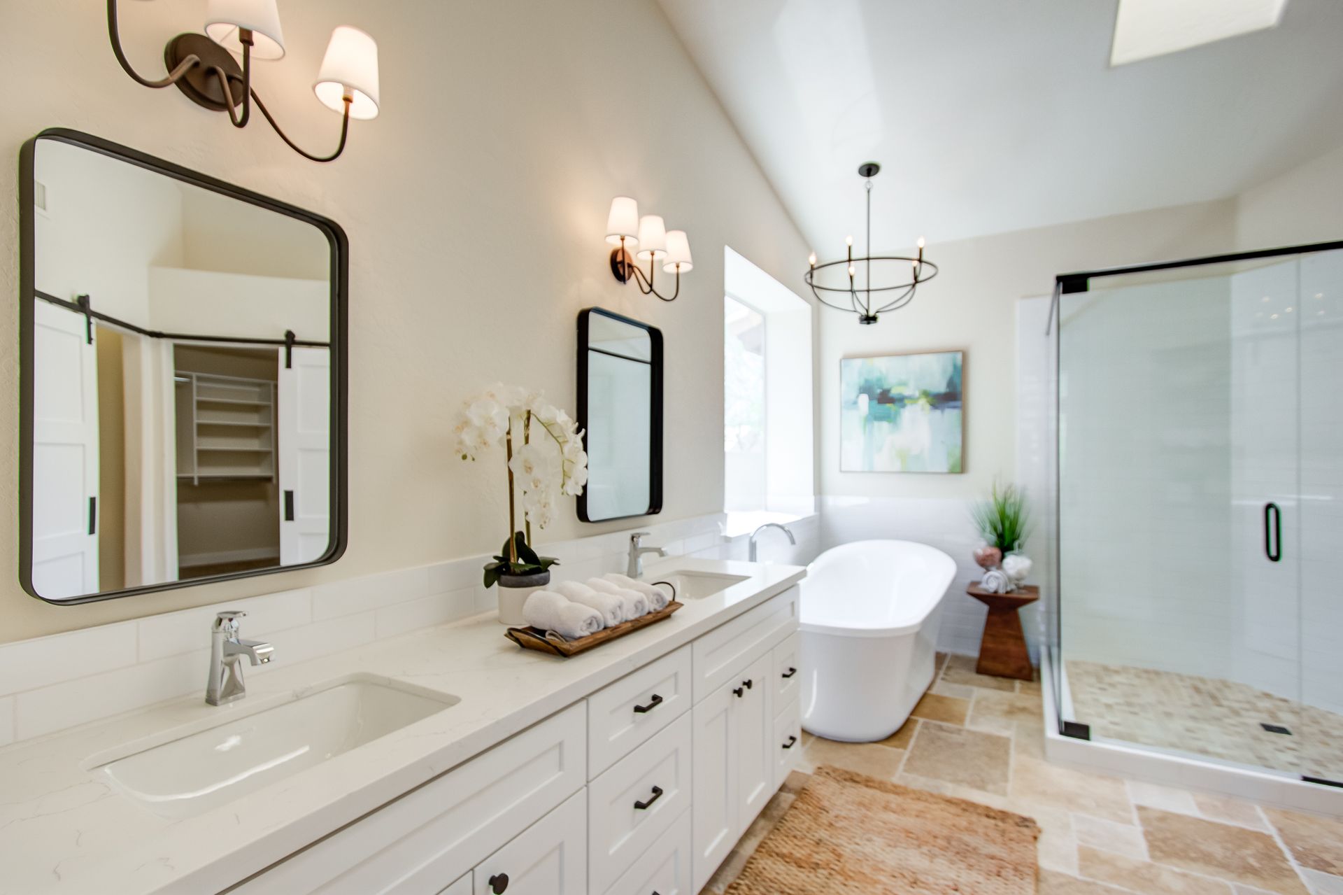A bathroom with two sinks , two mirrors and a bathtub.