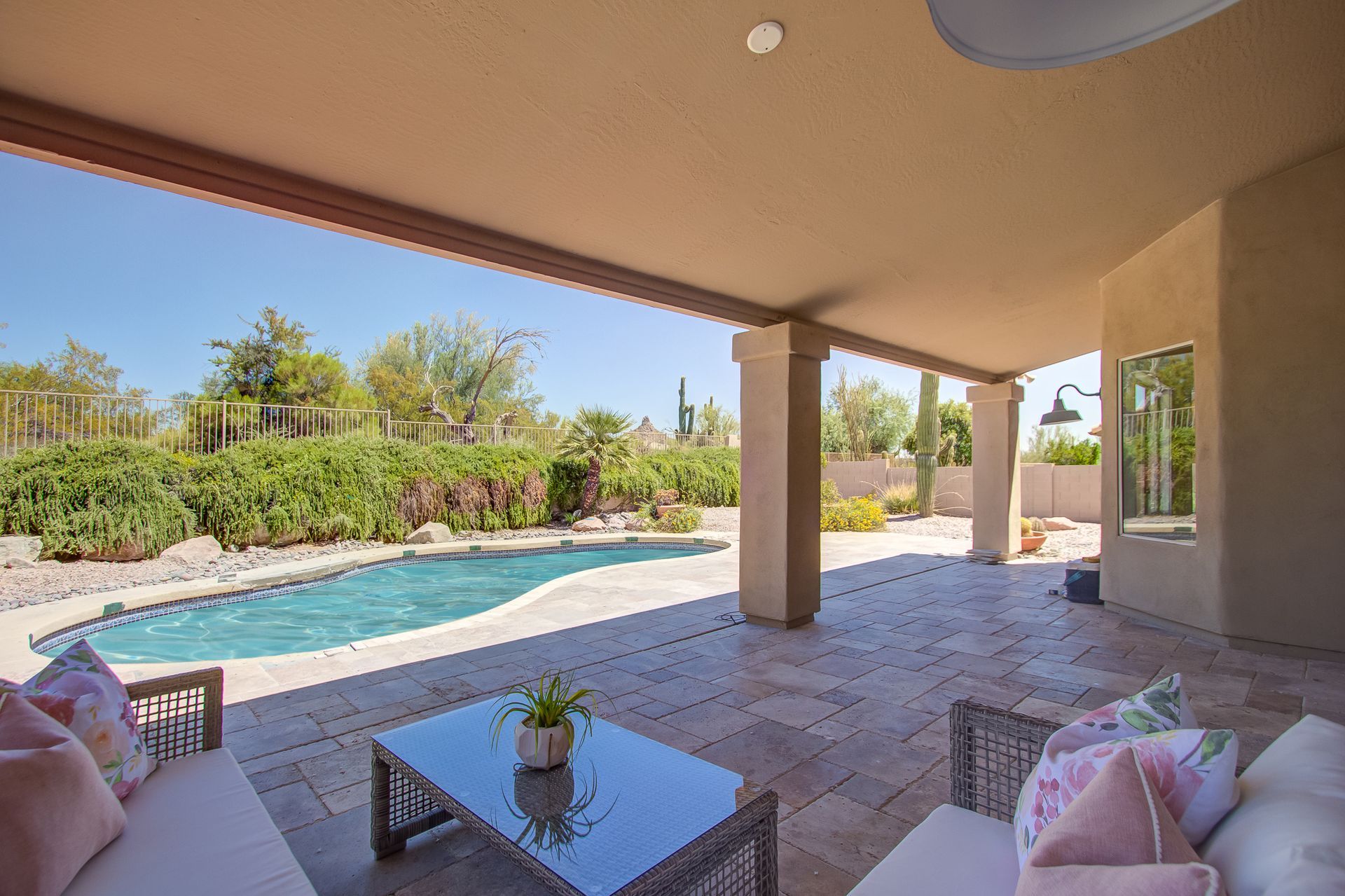 There is a large swimming pool in the backyard of a house.