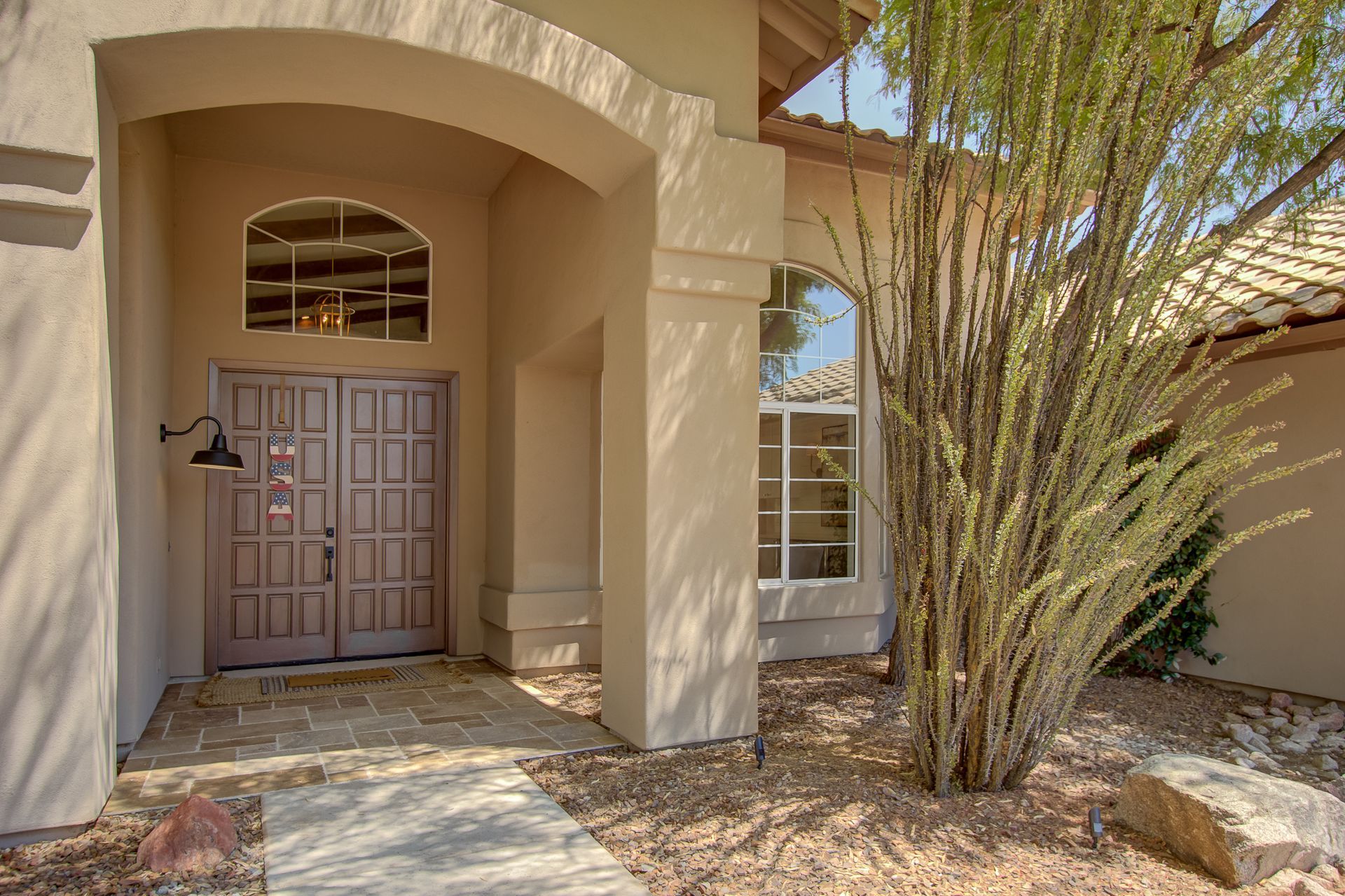 The front door of a house with a tree in front of it.