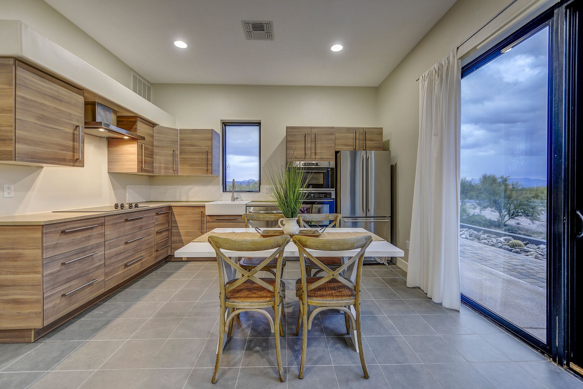 A kitchen with a table and chairs in it and a large window.